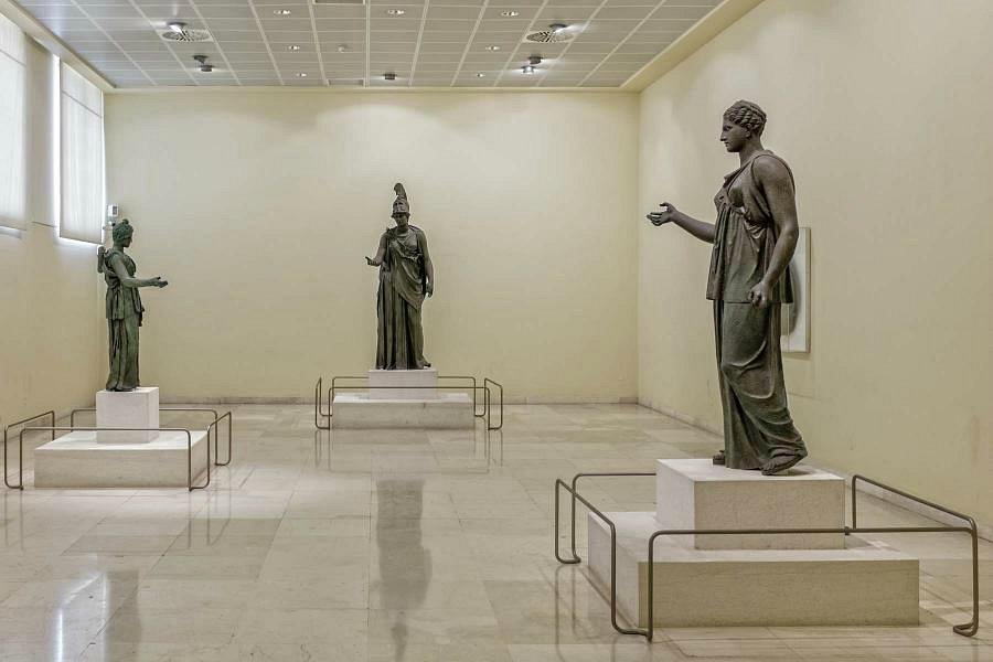 Ancient bronze statues displayed in a gallery at the Archaeological Museum in Piraeus, Greece.
