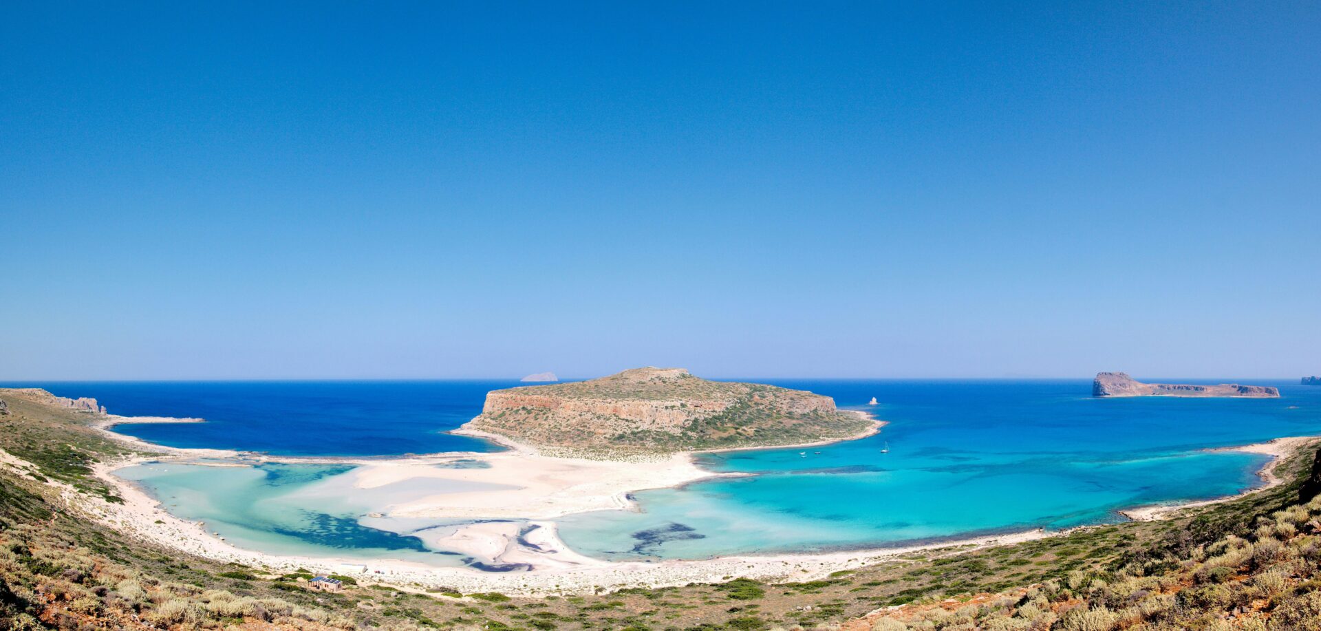 Natural beauty of Balos Lagoon with emerald-green shallows and a scenic backdrop of coastal cliffs