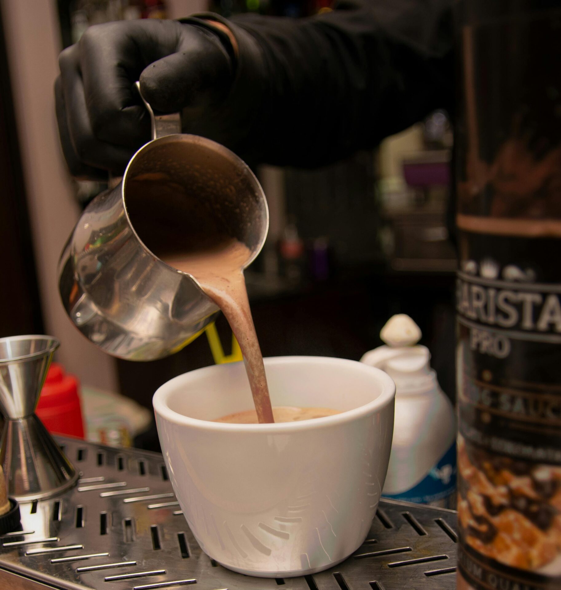 Barista pouring coffee on a ceramic cup