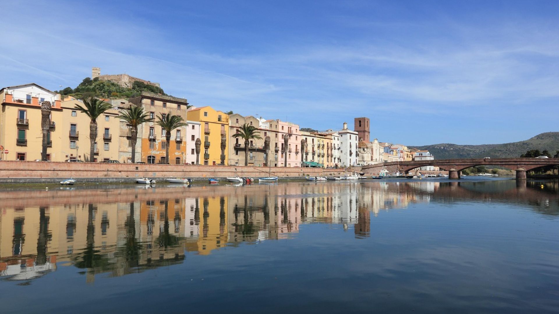 Pastel-colored houses and  dock small boats on Temo River in  Bosa, Sardinia, Italy.
