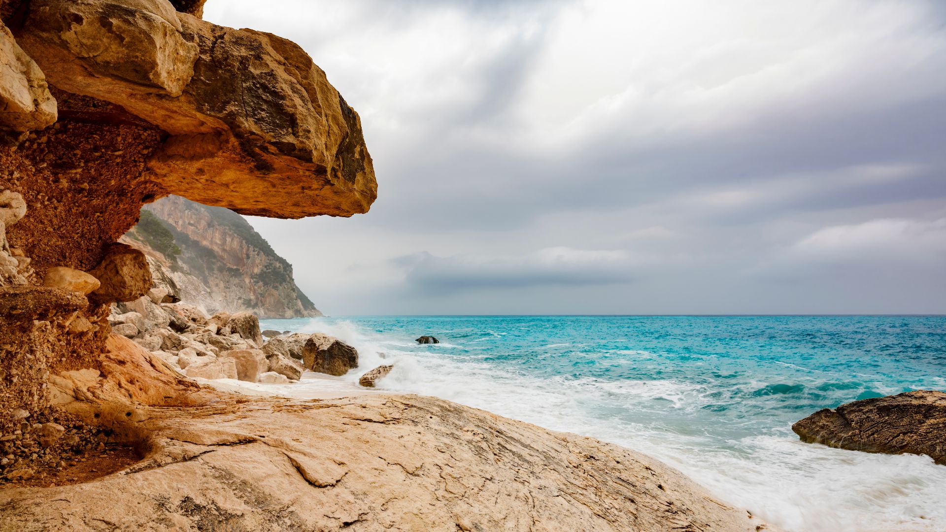 Scenic view of turquoise waters, rocky shores, and white sand beach of Cala Goloritzé in Sardinia, Italy