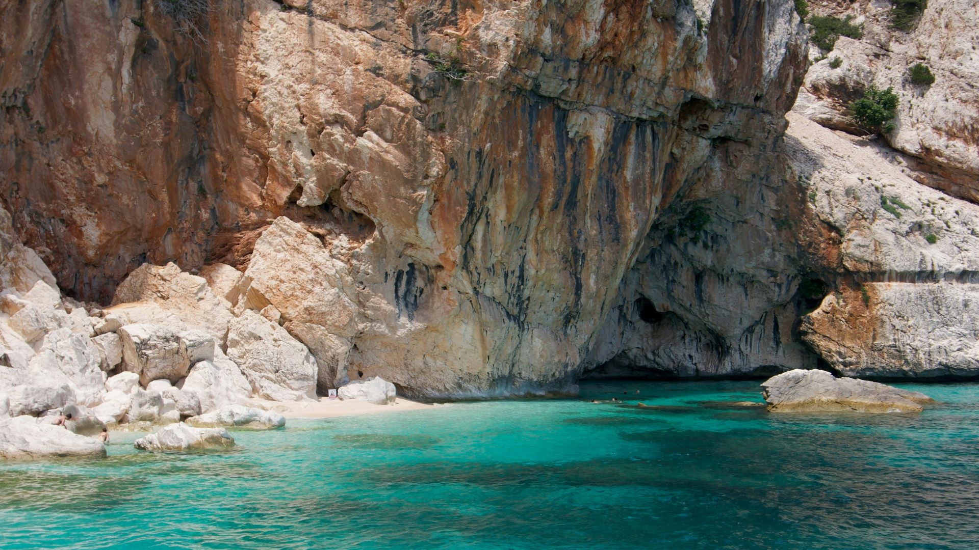 Turquoise water pops against the sheer limestone cliffs of Cala Mariolu, Sardinia, Italy