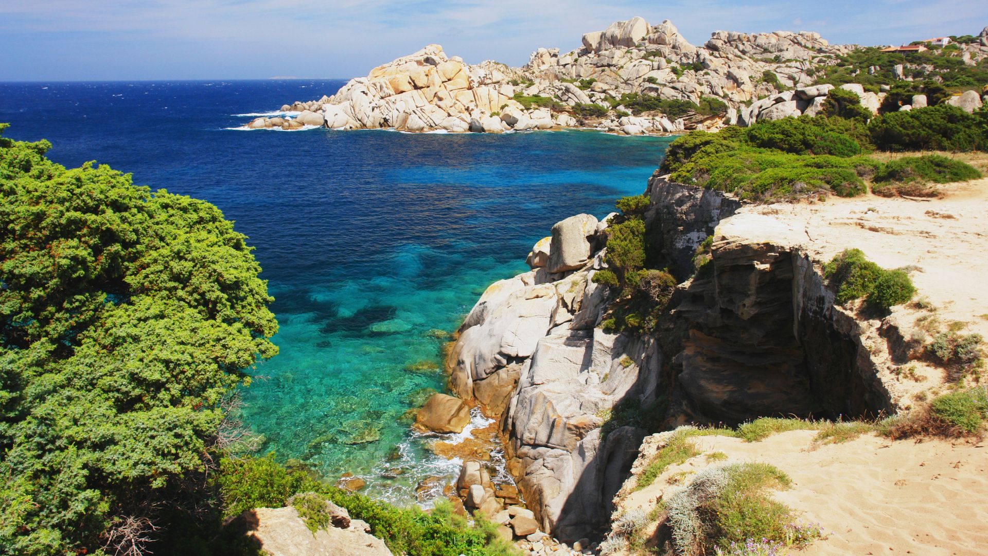 Scenic view of Capo Testa's rocky coastline and clear turquoise waters in Sardinia, Italy.