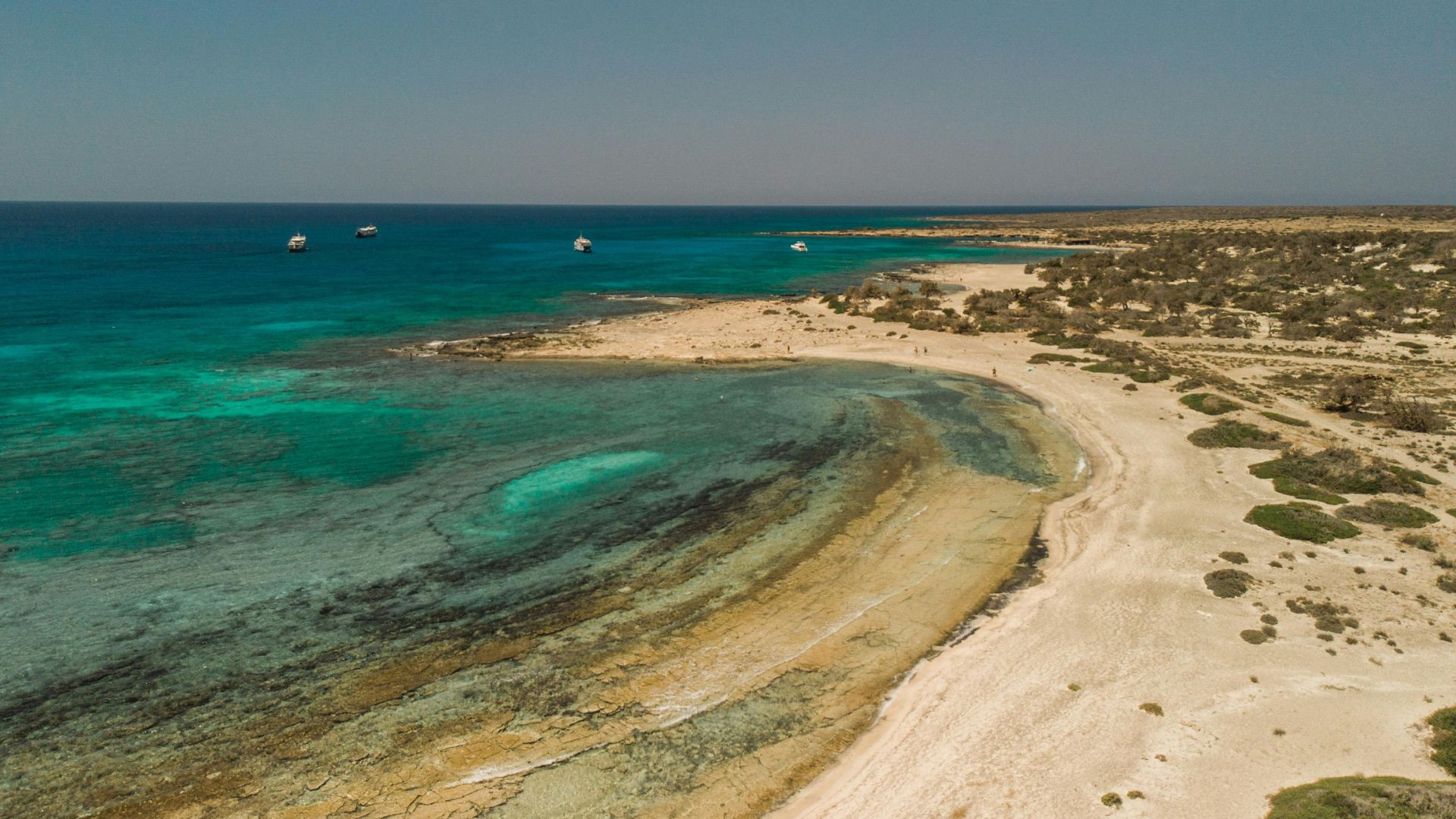 An aerial view of Chrysi Island's coastline with turquoise waters and sandy beaches.
