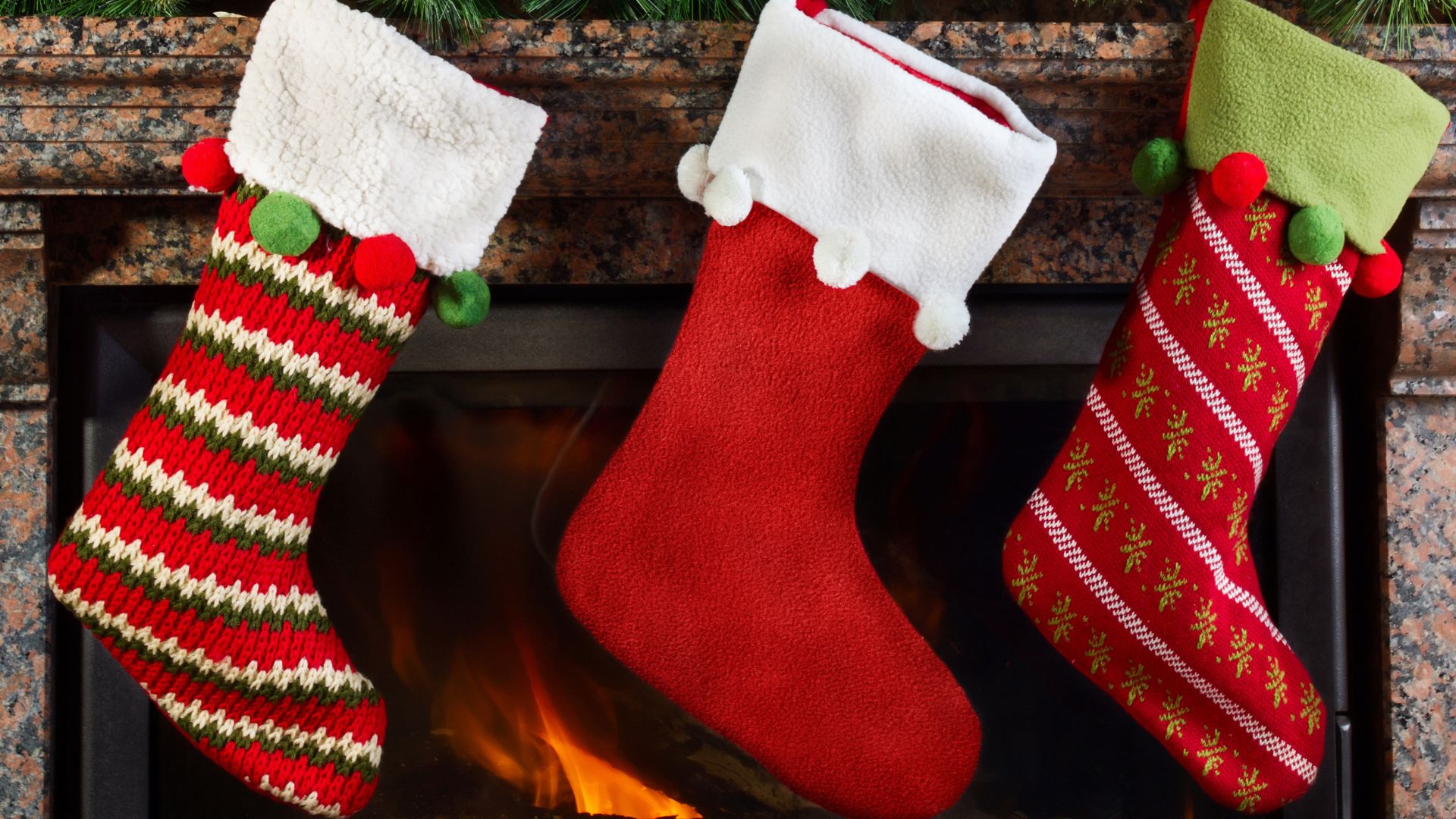 Image shows Christmas stockings hanging on the chimney. 
