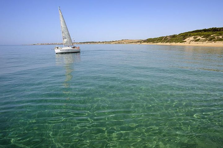 Sunny beach in Crotone, Italy, with golden sand and clear blue waters of the Ionian Sea