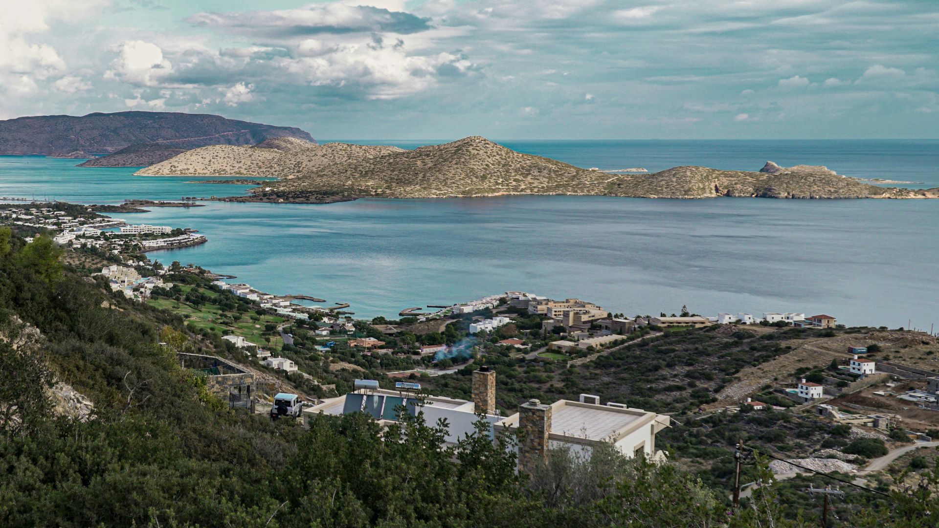 Panoramic view of the Elounda Ilion Hotel and the scenic coastline of Mirabello Bay in Crete.