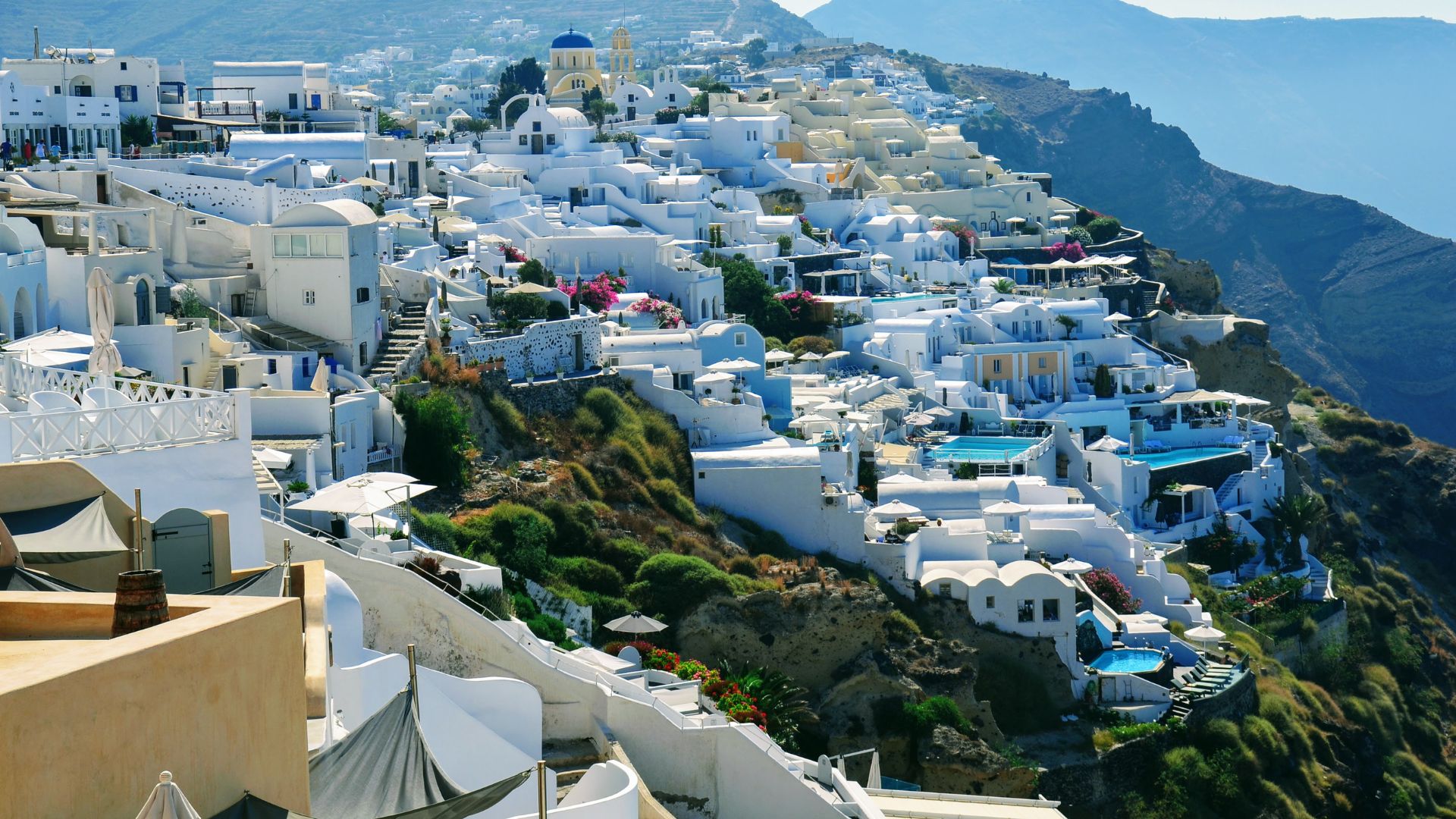 A hillside town in Santorini, Greece, with white buildings and blue accents.
