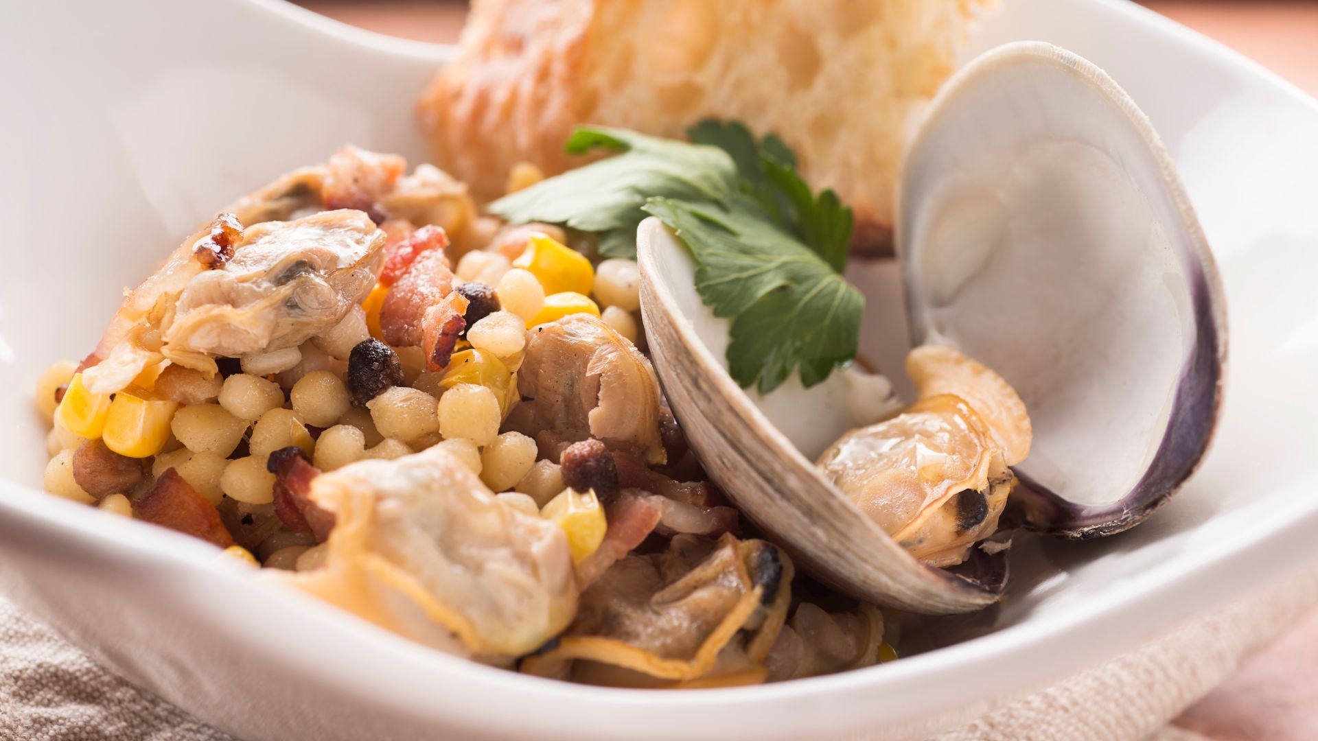 A Fregola with some seafood and clams on a plate.