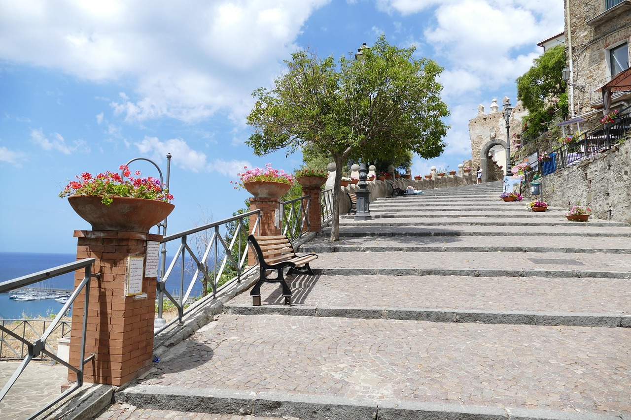  Scenic stone staircase lined with flowers and benches in Agropoli, Cilento, Italy, with views of the sea in the background.