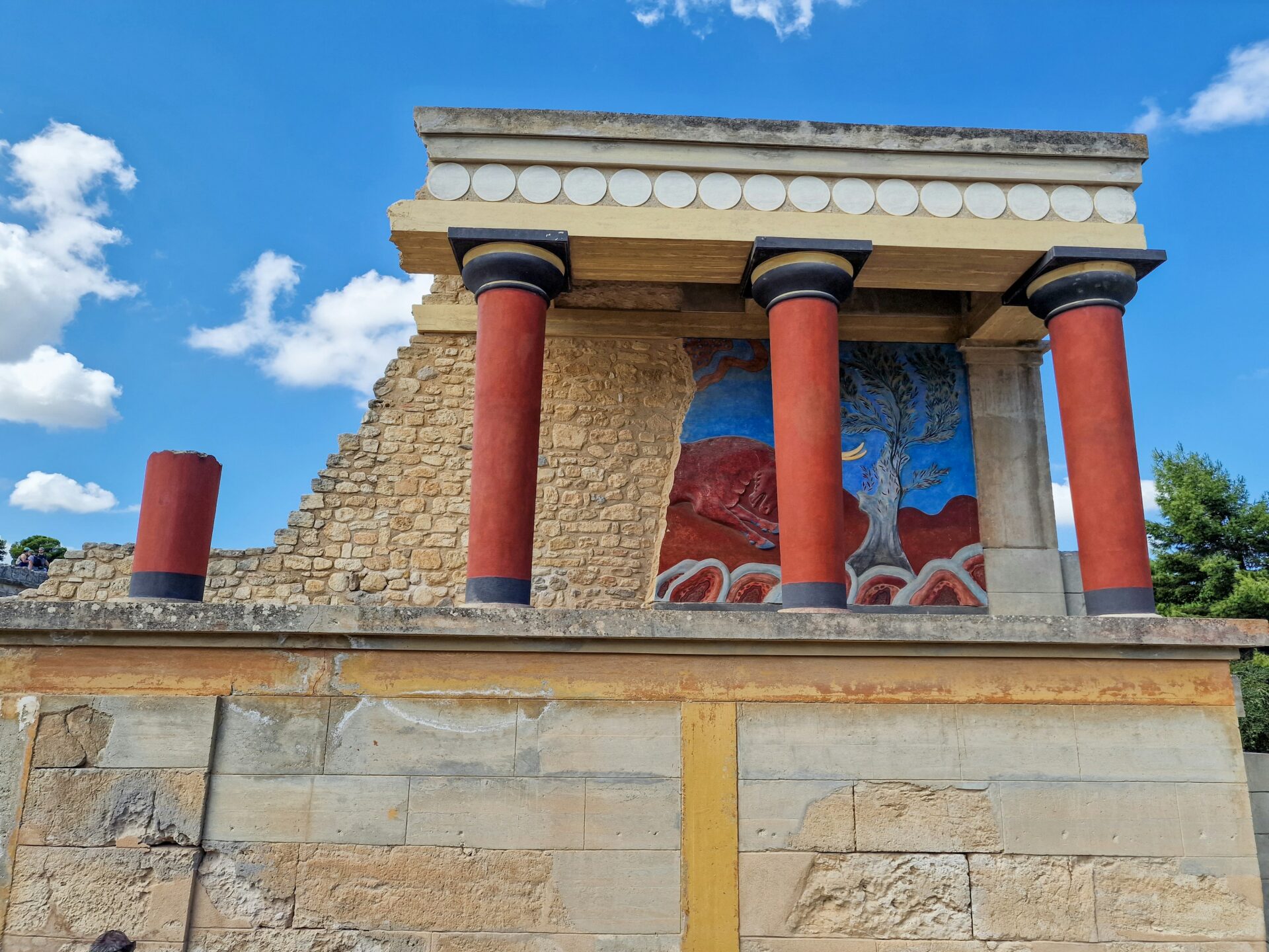 Restored columns of Knossos Palace under a clear blue sky