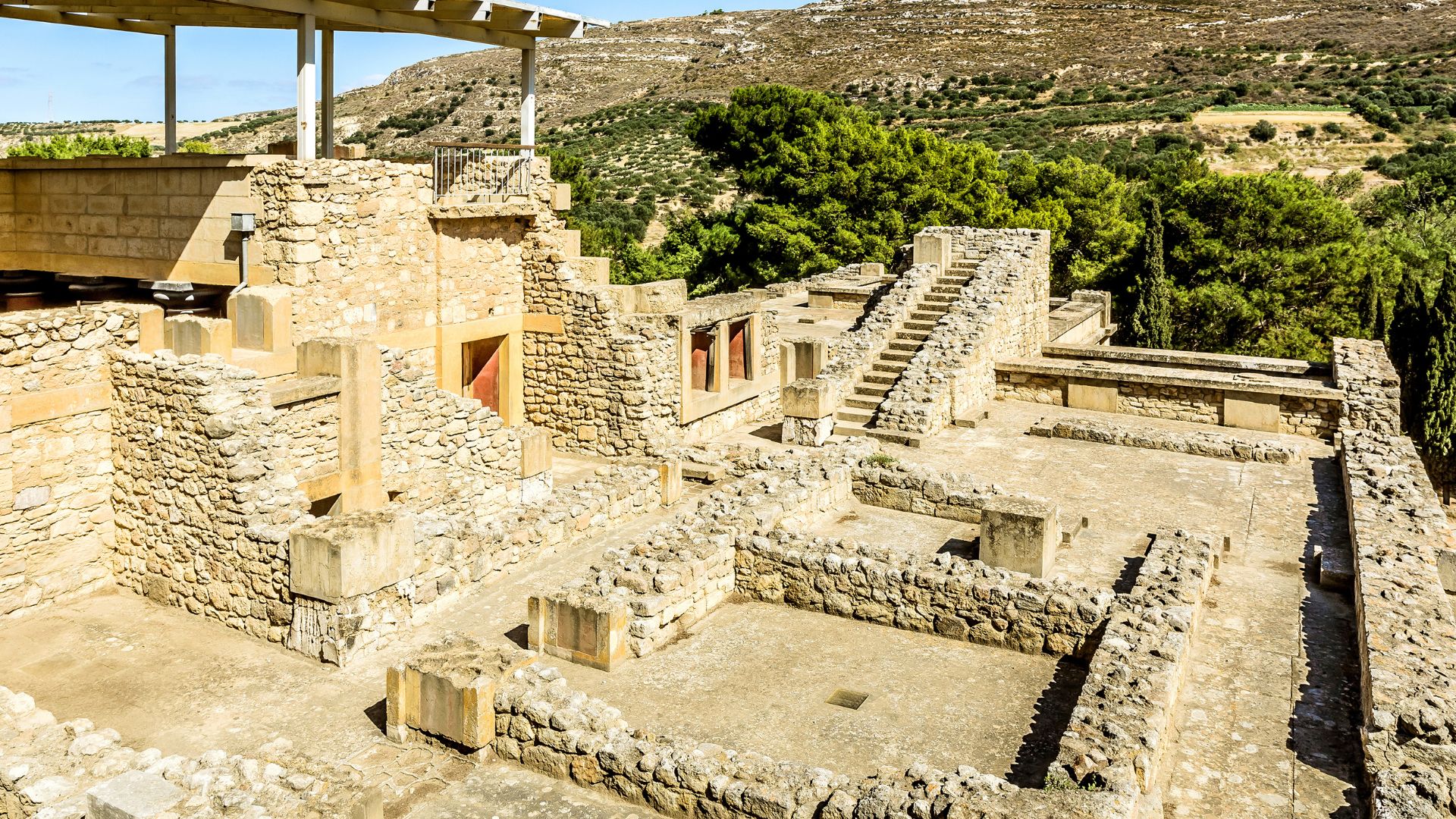 Ruins of the ancient Minoan palace of Knossos on Crete, featuring stone walls, courtyards, and stairways.
