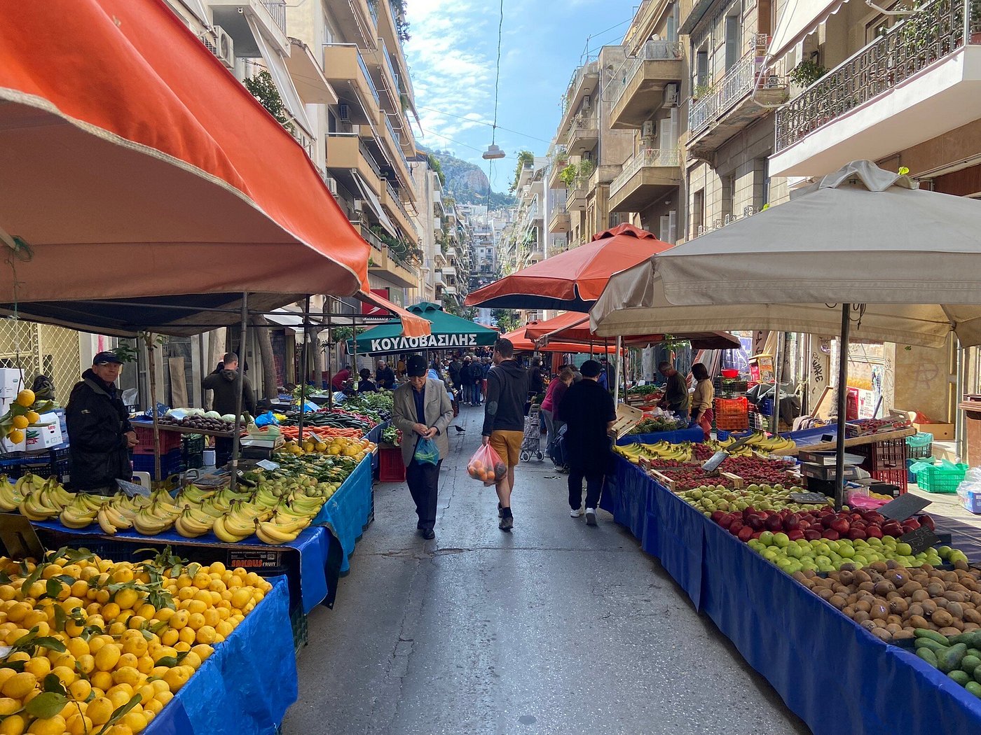 Fresh fruits and vegetables displayed at Laiki Agora Farmer’s Market on a lively street in Greece.
