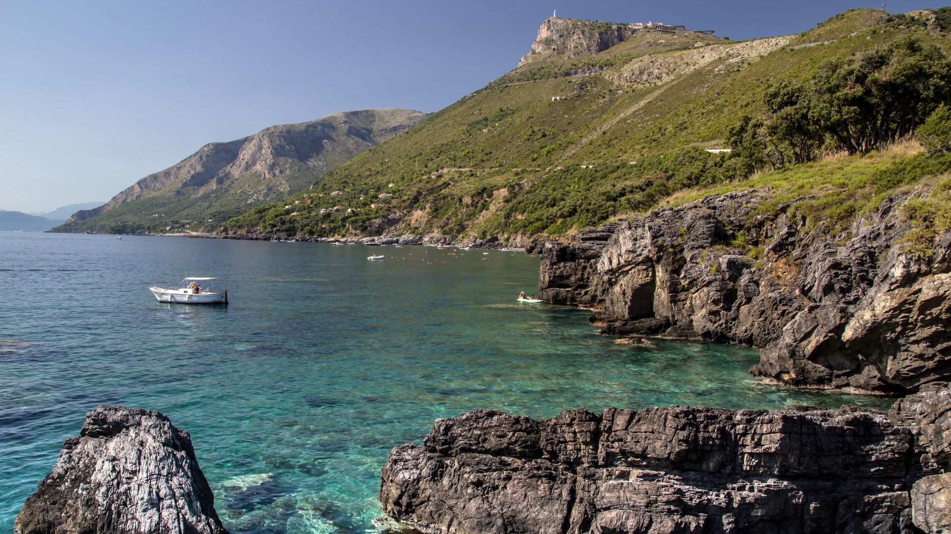 Image shows crystal  clear water and rocky cliffs in Maratea, Basilicata, Italy.