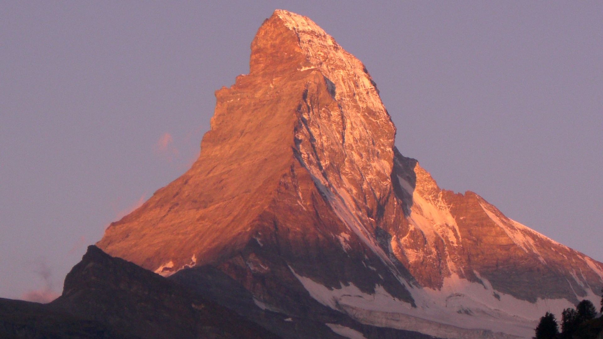 The Matterhorn, a towering peak in the Swiss Alps, bathed in the warm light of the setting sun.