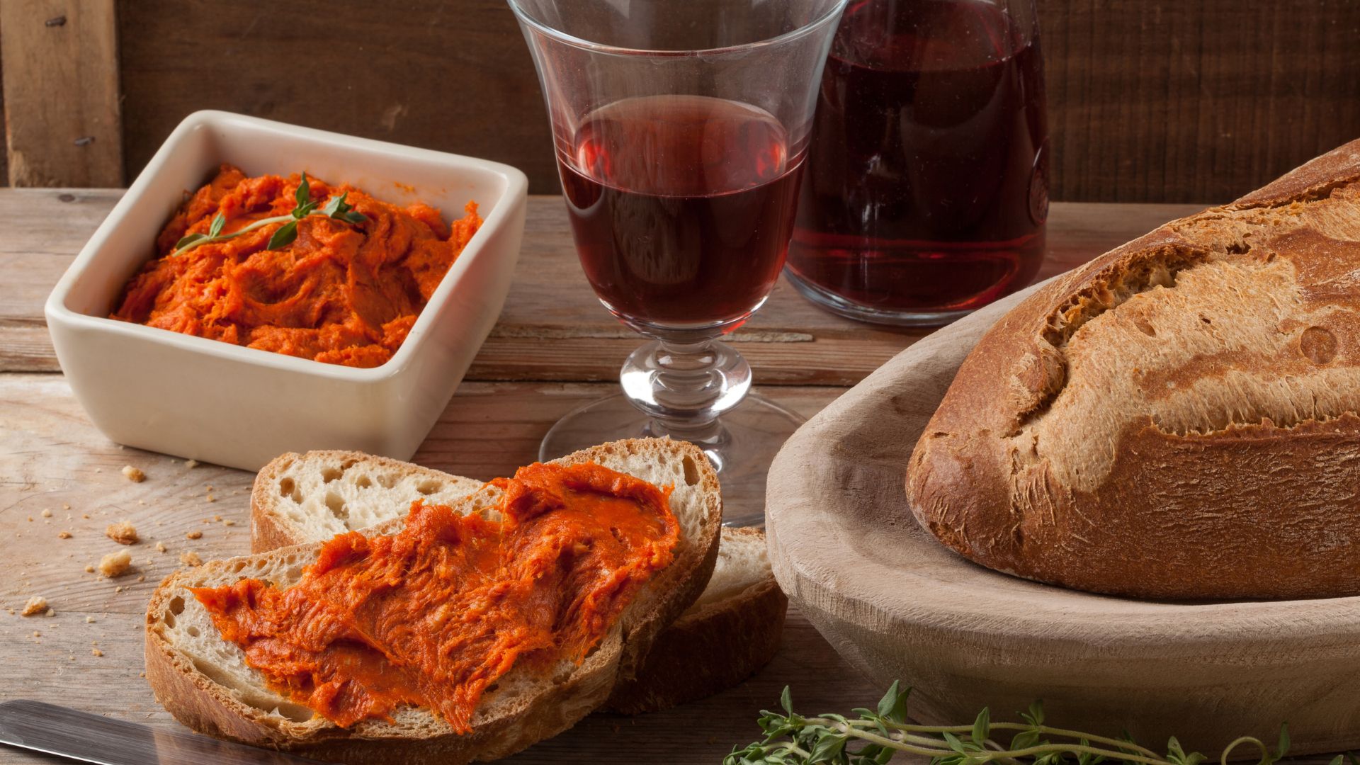 Image shows a Nduja, break, and a red wine. 