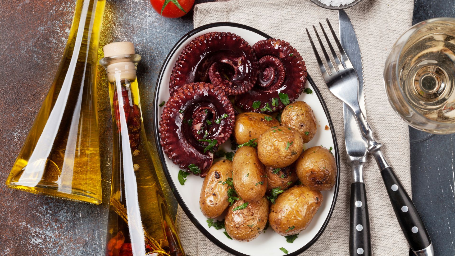 Image shows Octopus with potatoes and olives.