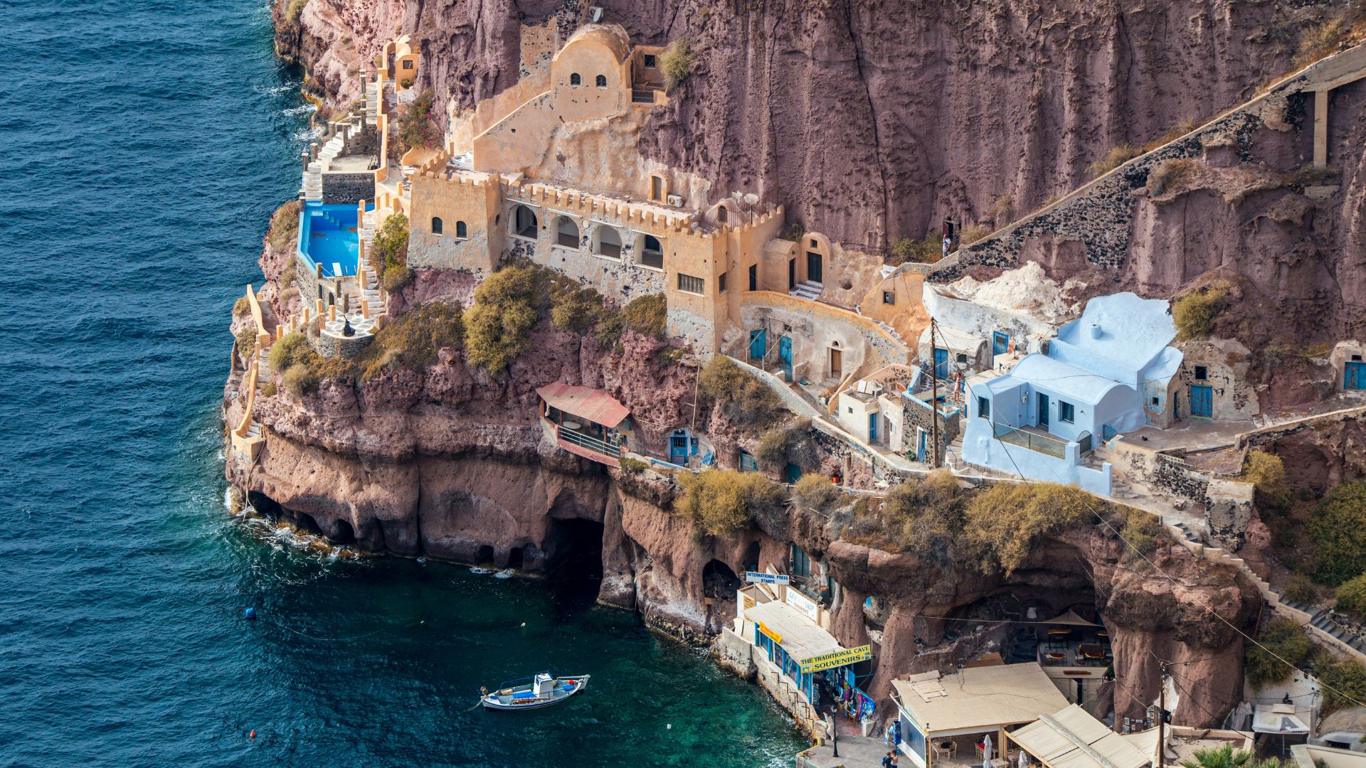 A coastal village with whitewashed buildings on a cliff overlooking the sea.