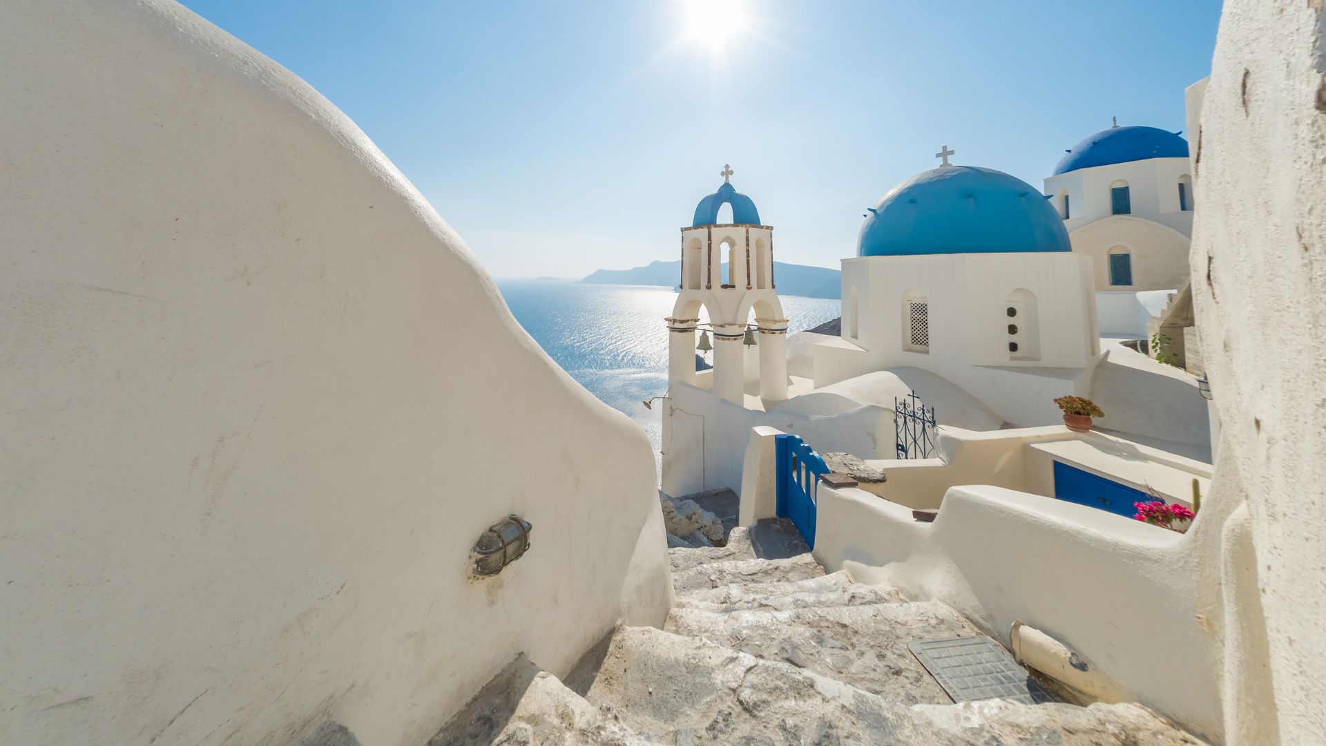 Iconic Santorini view with whitewashed buildings and blue-domed churches overlooking the sea.