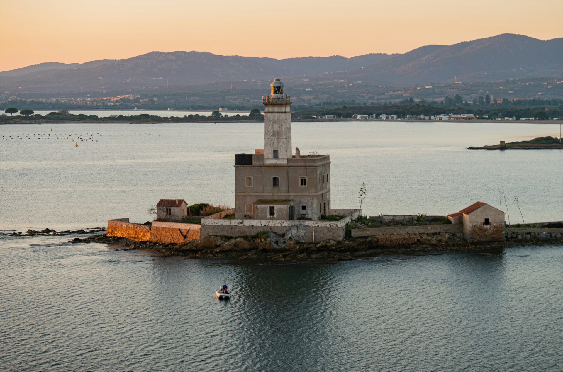 Small fishing island in Olbia featuring a historic lighthouse overlooking the turquoise sea