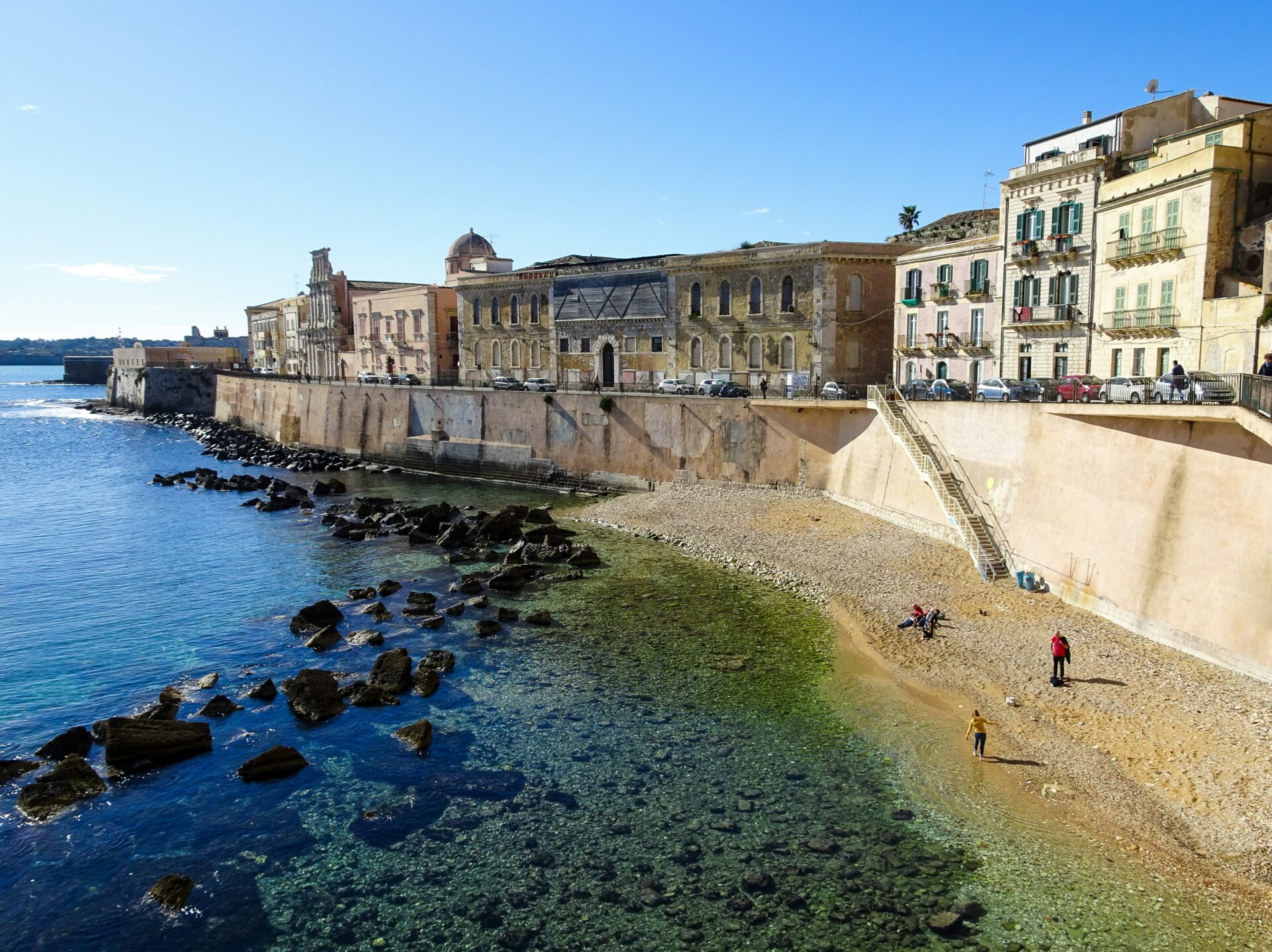 Elegant historic buildings line the waterfront promenade in Ortigia