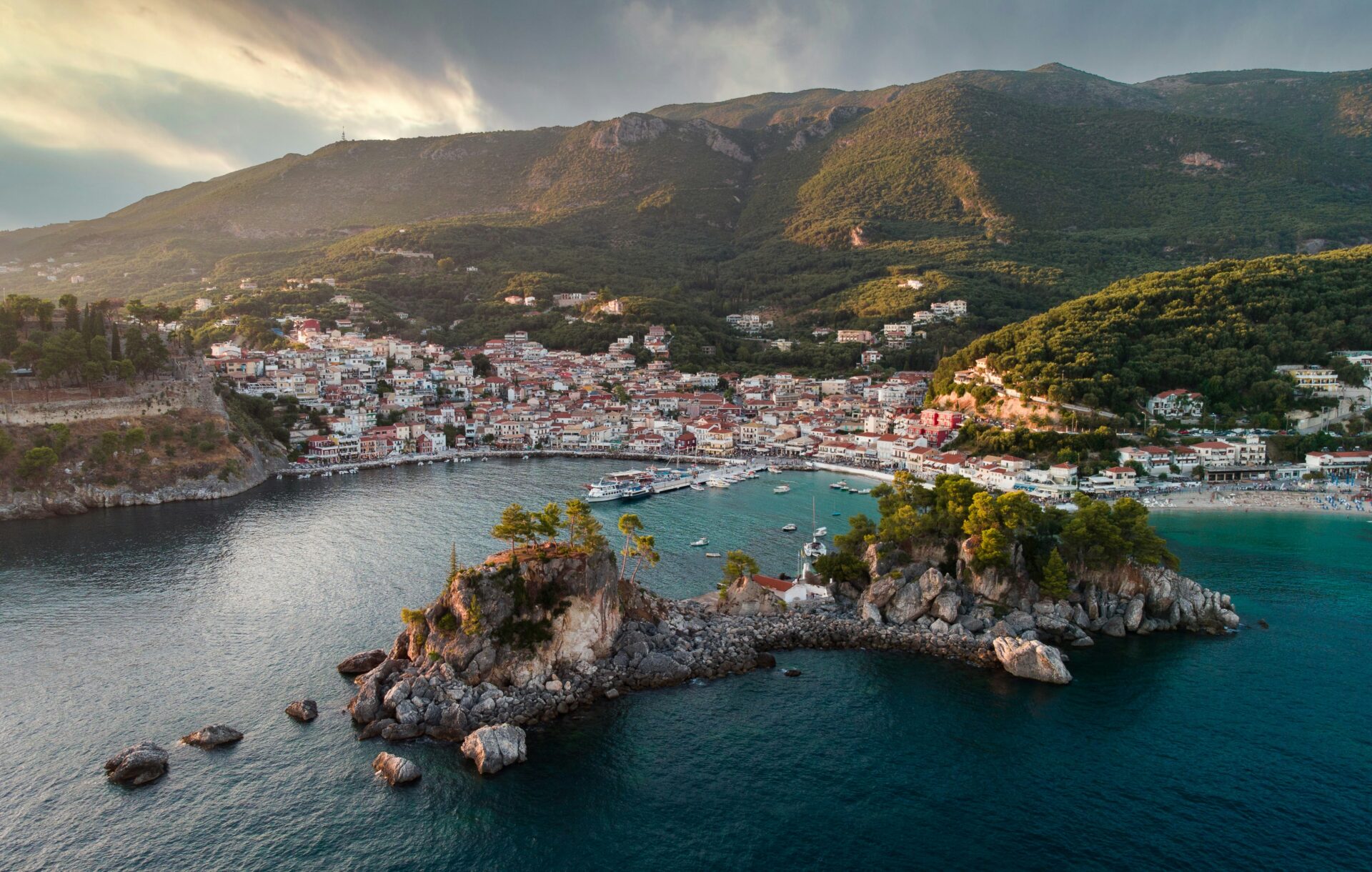 Aerial shot of Panagia Islet with its white chapel and bell tower nestled among trees