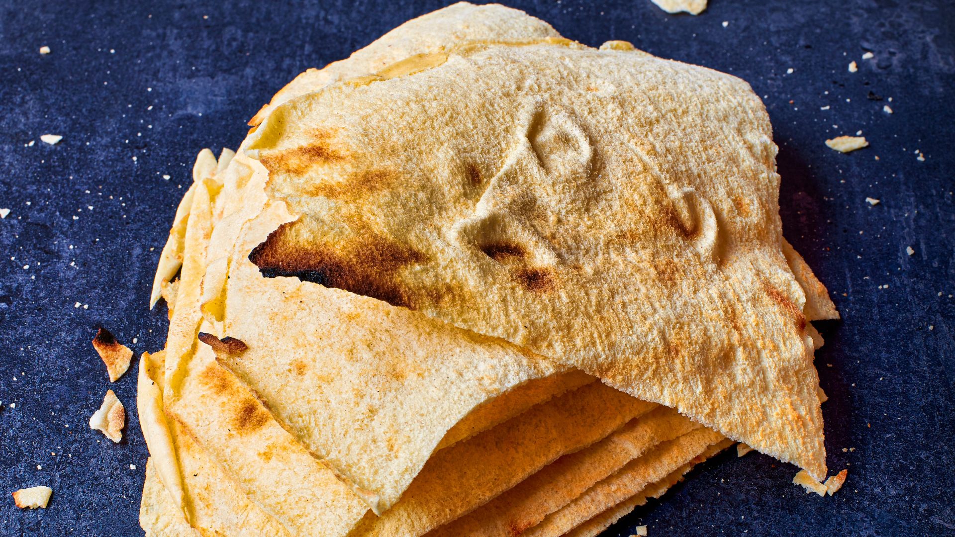 The image shows a stack of Pane carasau, a traditional flatbread from Sardinia.