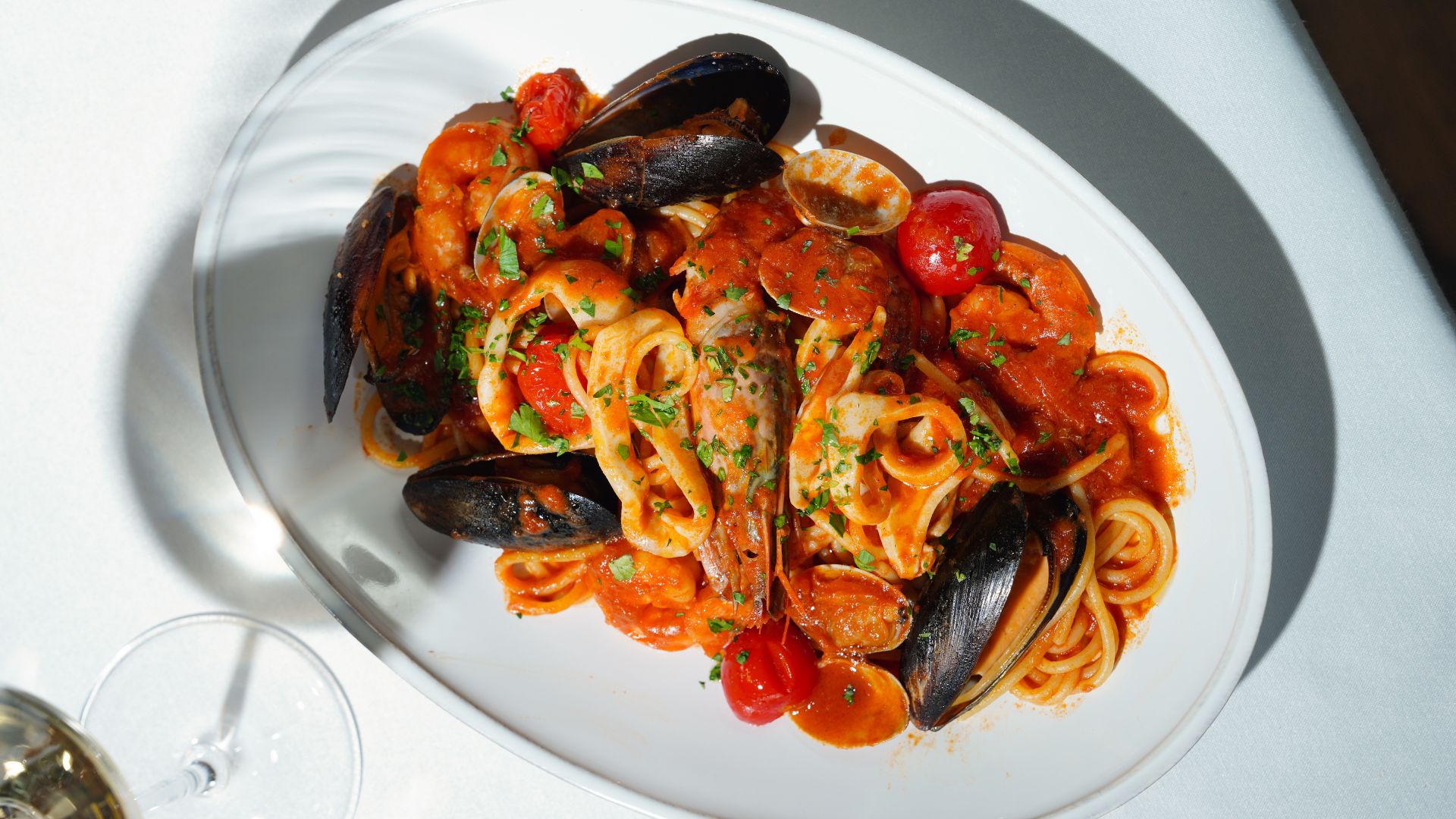 Image shows Pasta loaded with mixed seafood and local tomatoes.