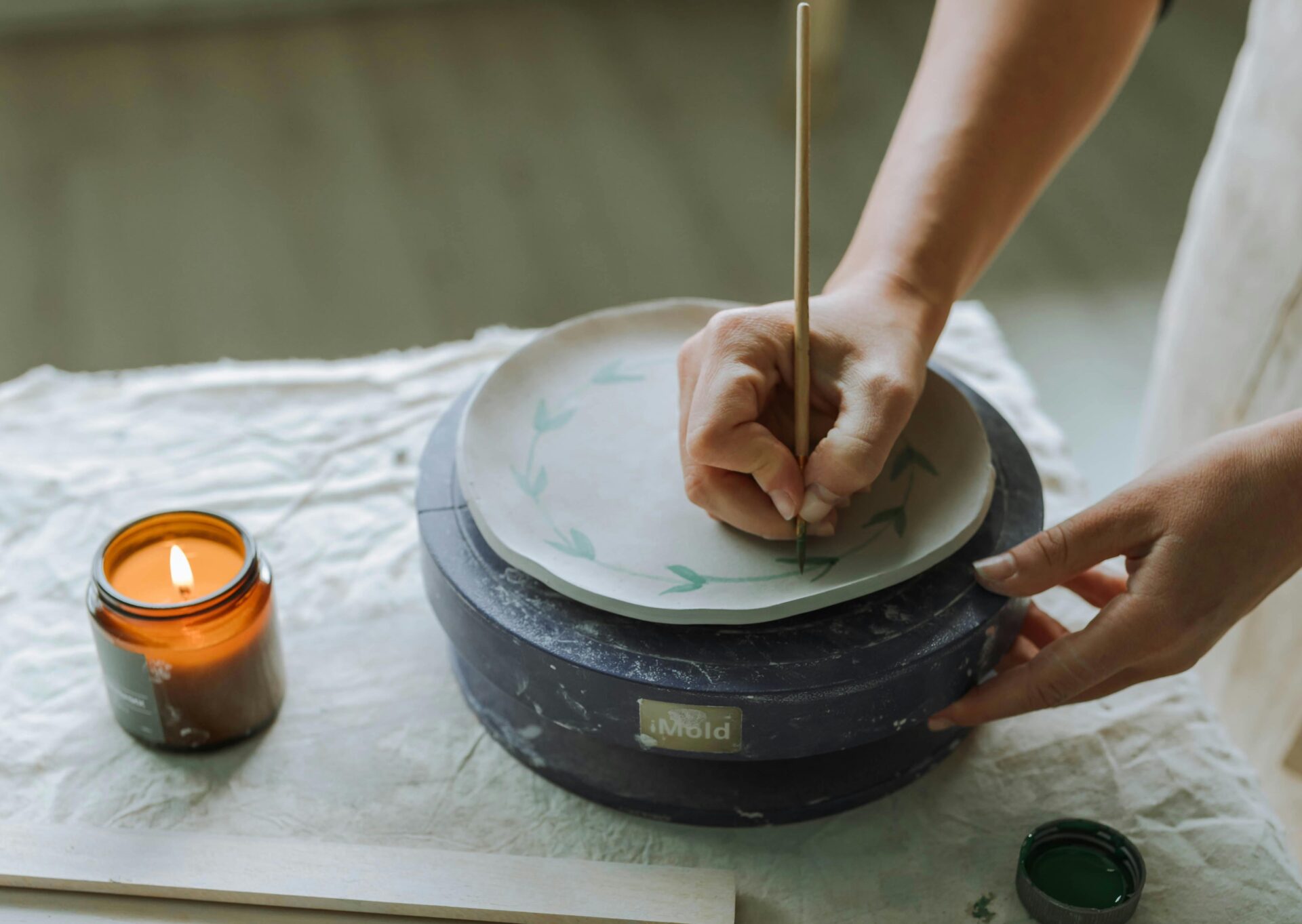 Person Painting on Wet Clay Plate