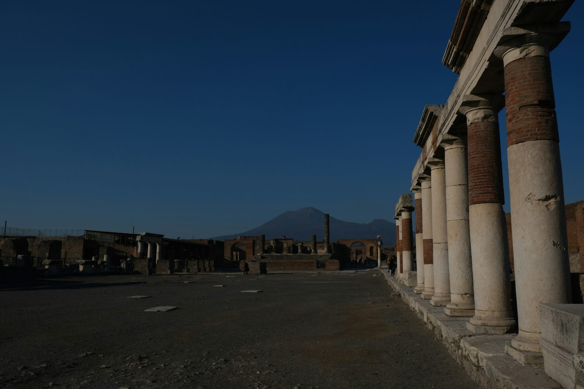 Ruins of the Forum at the Archaeological Park of Pompeii, with Mount Vesuvius in the background.