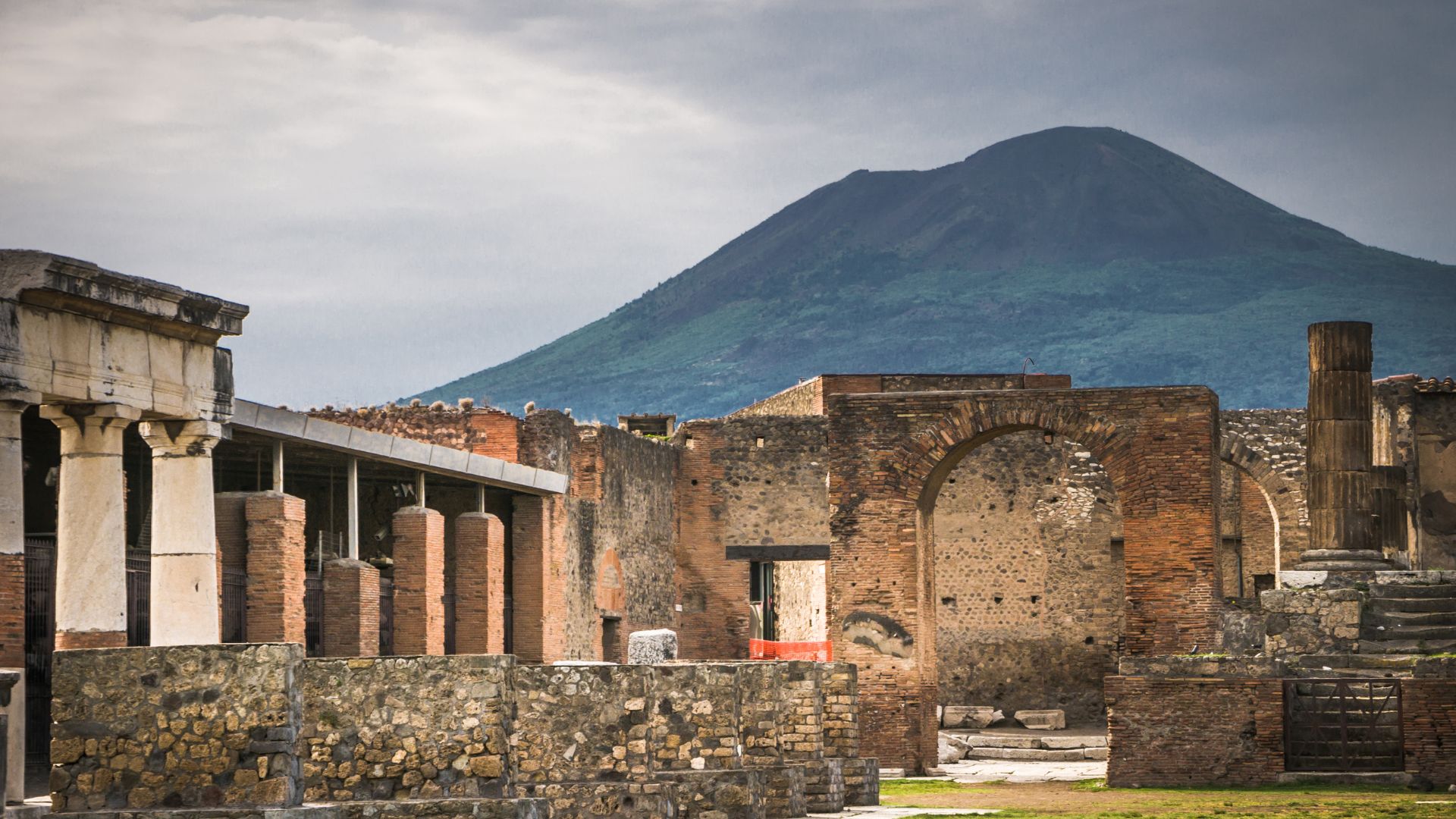 Ruins in Pompeii, Italy with mountain as background.