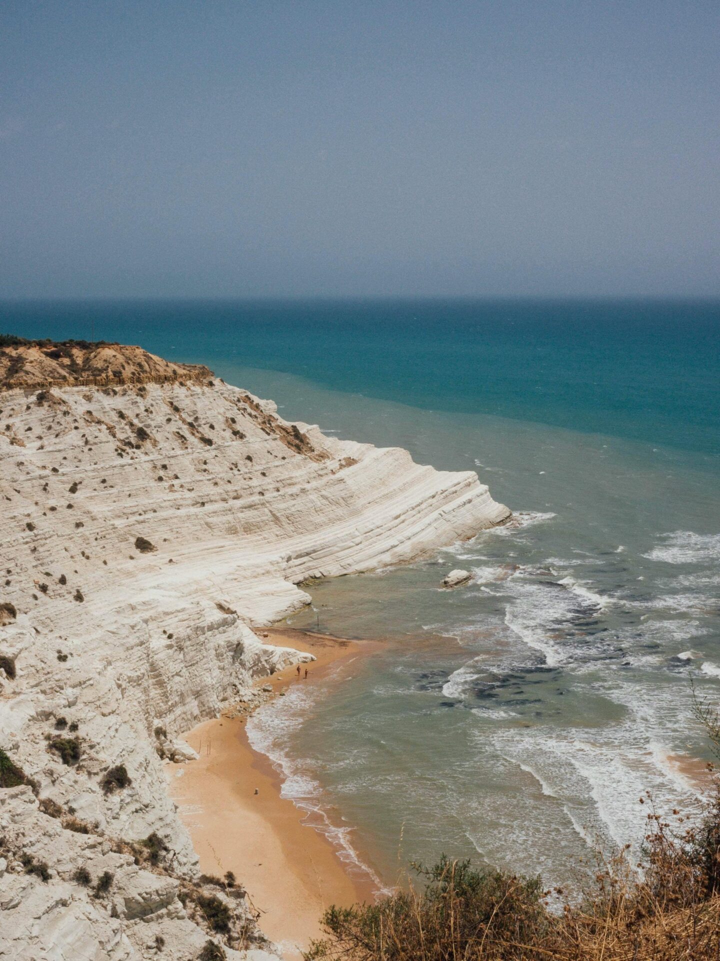 Wide shot of Scala dei Turchi, showing the vast, white cliffs stretching along the coastline