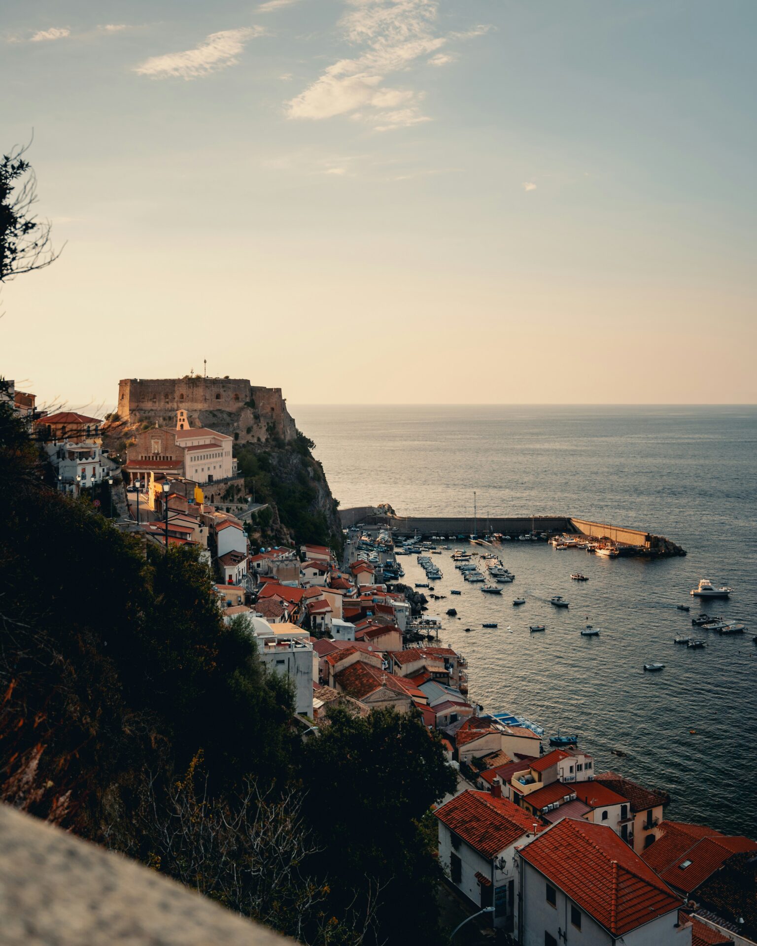 Colorful traditional houses perched on the rocky shoreline of Scilla, Italy