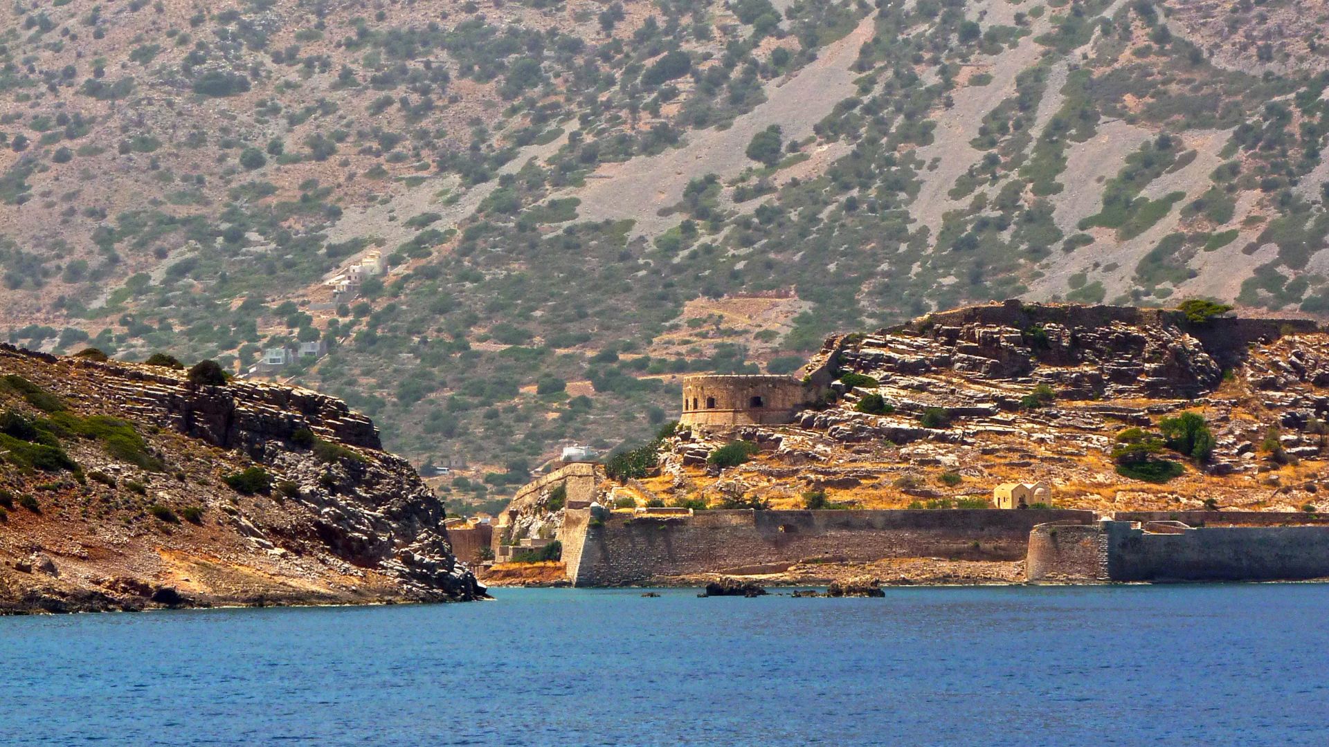 Spinalonga Island with its Venetian fortress, surrounded by the sea and rocky terrain of Crete.