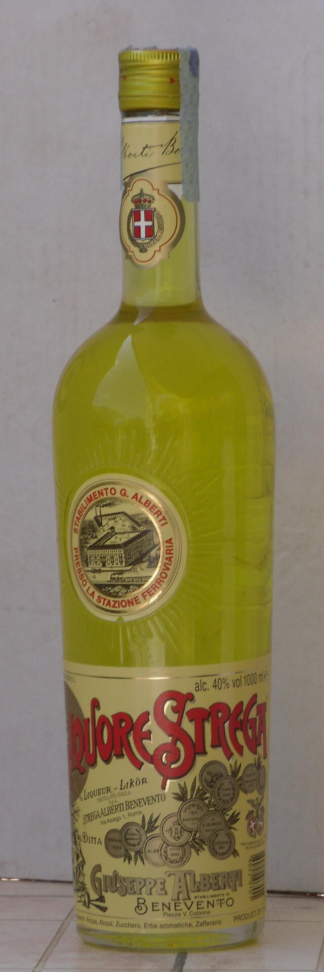 A bottle of Strega Liqueur, a bright yellow herbal liqueur made in Benevento, Italy.