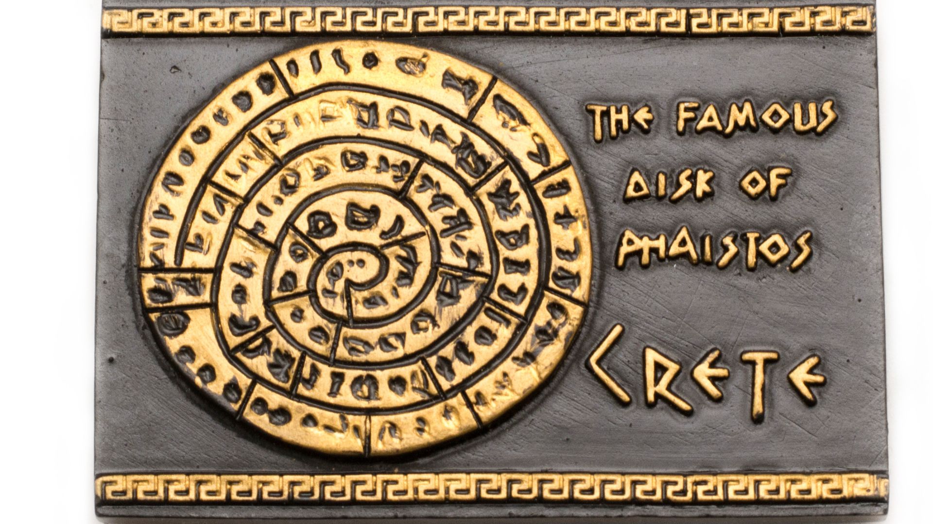The Phaistos Disc, a clay artifact with a spiral of stamped hieroglyphic symbols, on display at the Heraklion Archaeological Museum.
