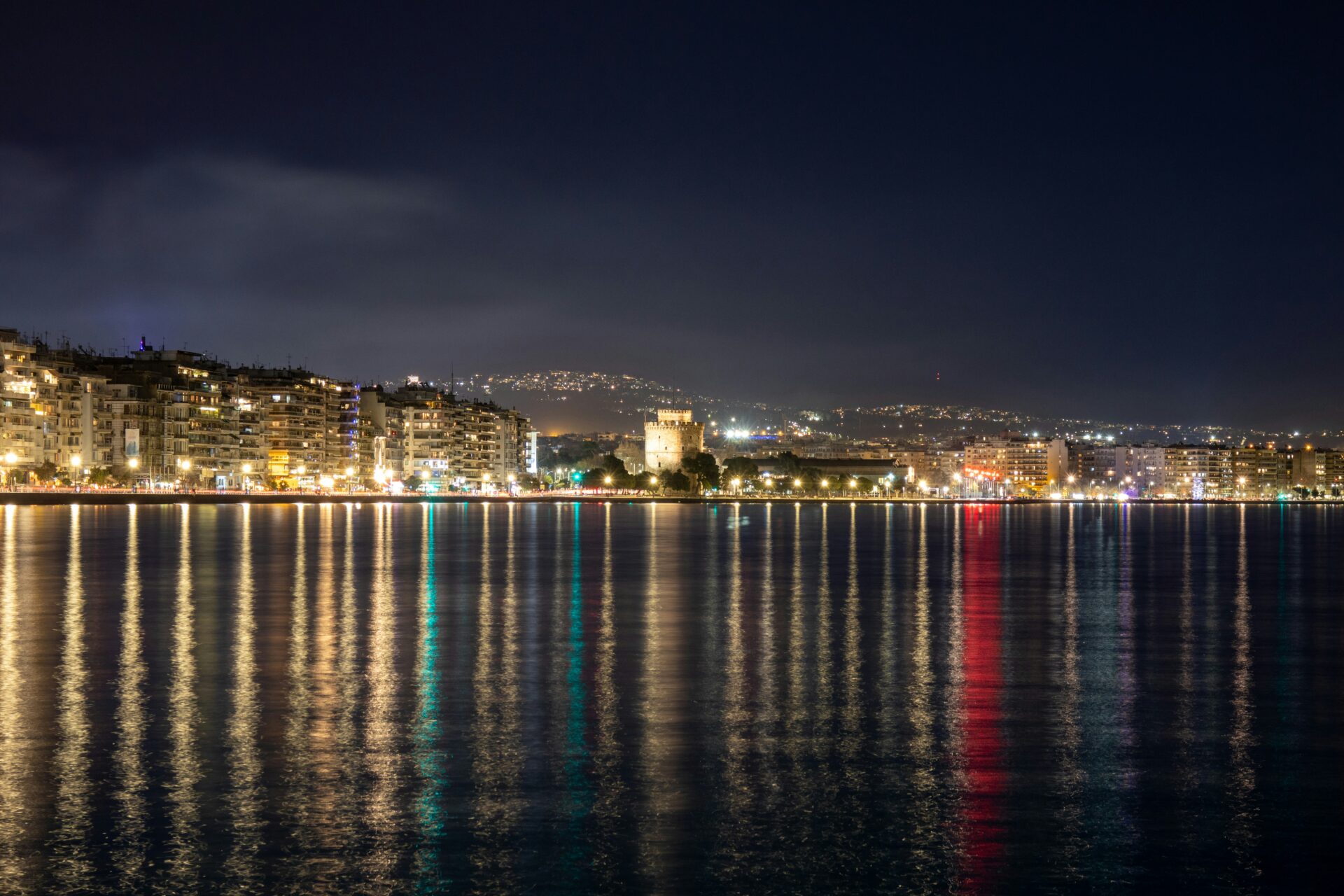 Thessaloniki at night with city lights reflecting on the calm waters of the Thermaic Gulf