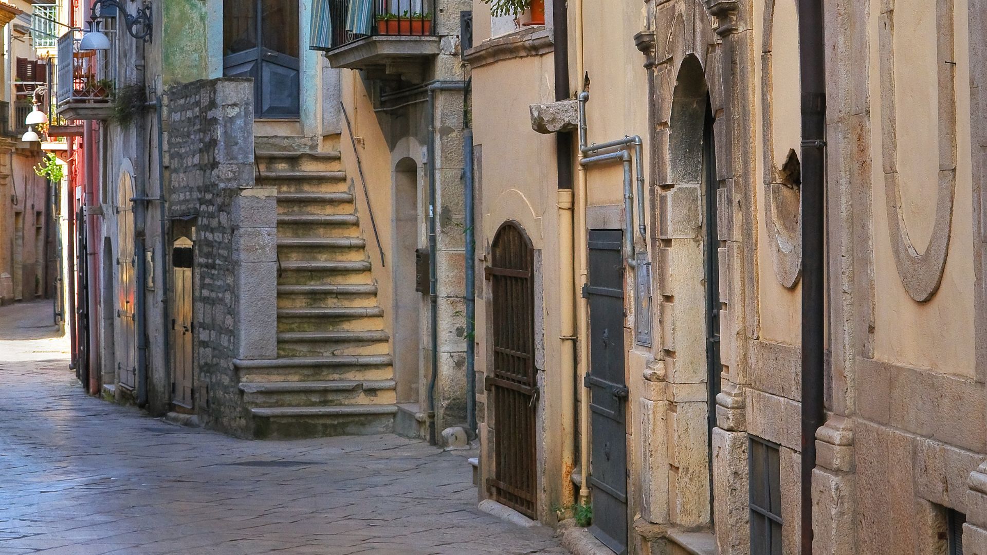 Narrow street with stone buildings in Venosa, Potenza, Italy