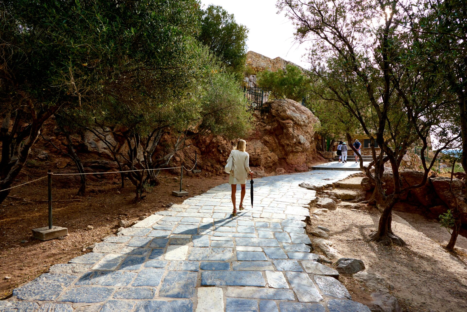 Woman Walking On Cobblestone Pathway in Athens Greece