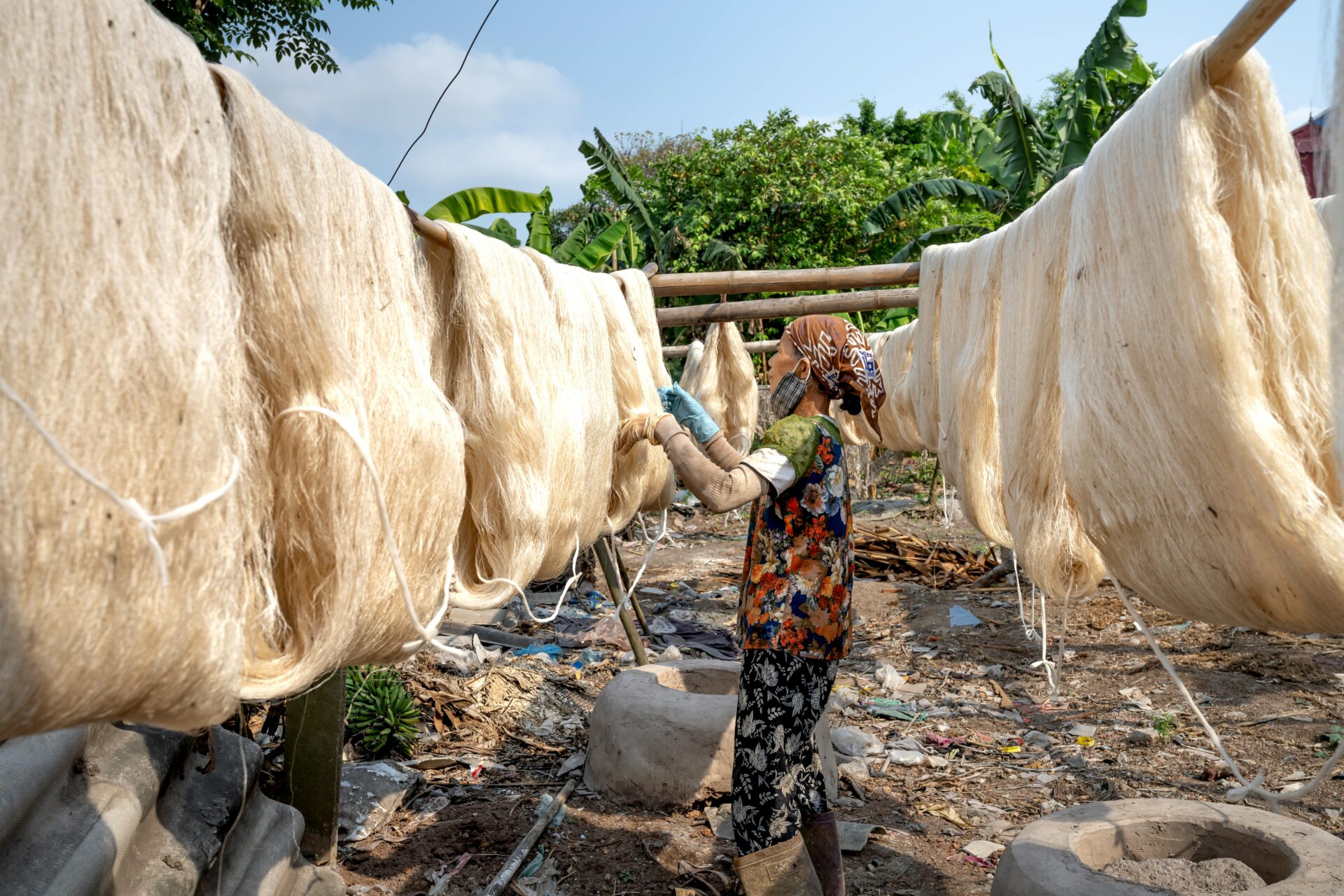 A woman carefully inspecting drying silk threads, a key part of the traditional silk-making process along Catanzaro's Silk Road.