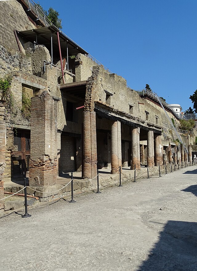 Ruins of the Decumanus Maximus street lined with ancient columns in Herculaneum, Italy.