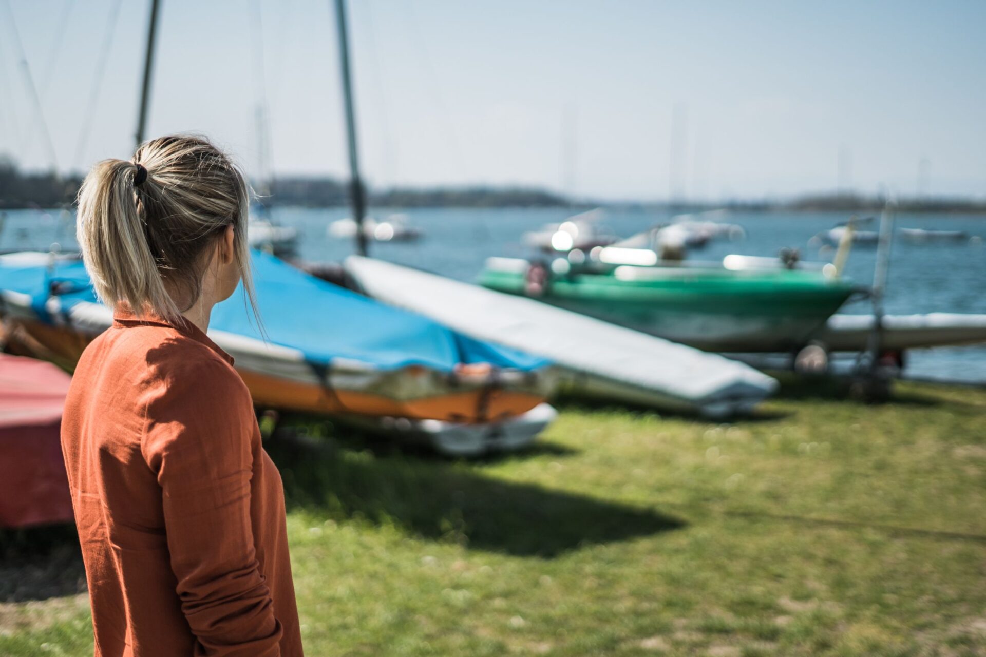 woman standing beside sailboats