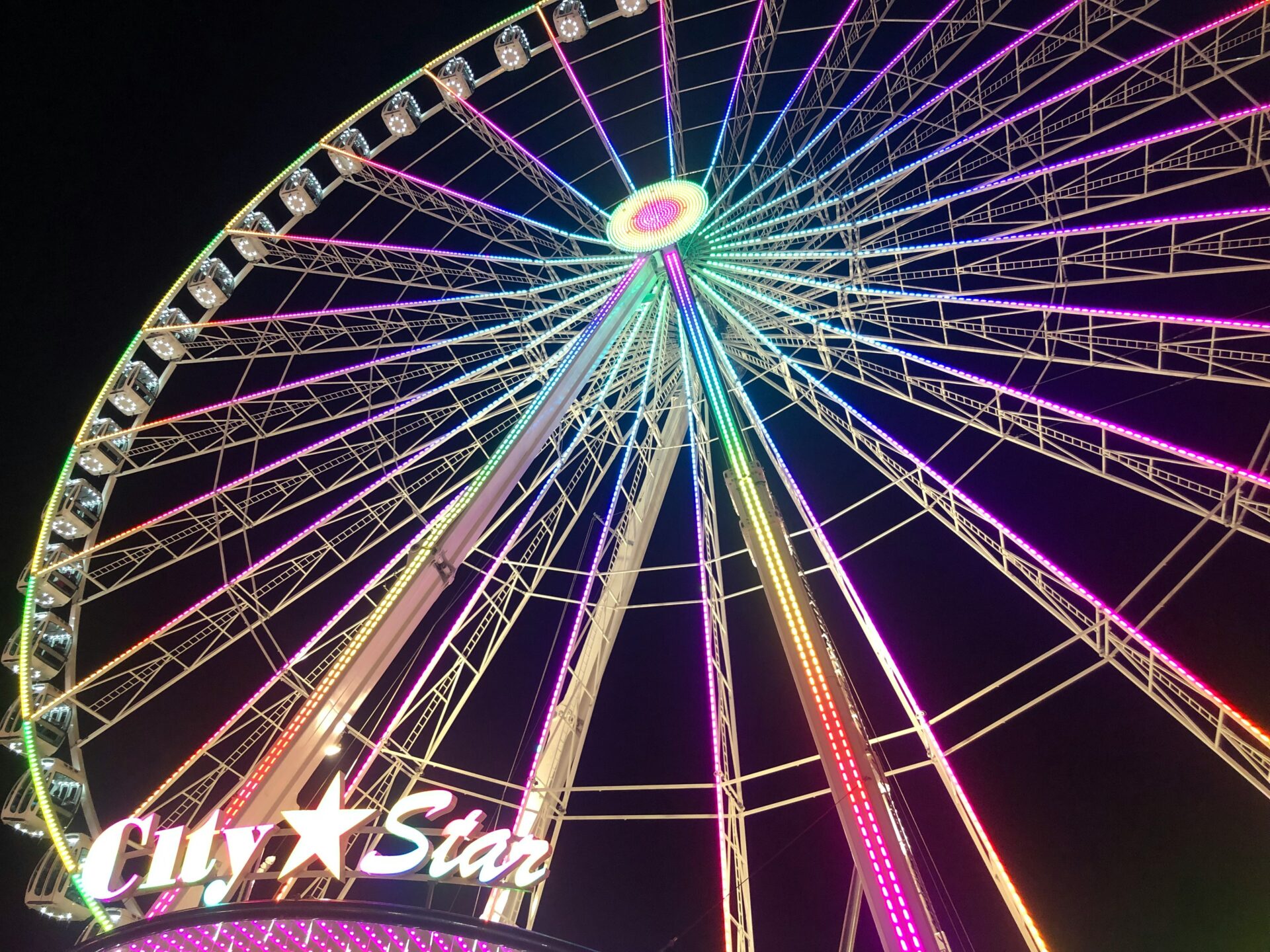 A brightly lit Ferris wheel towering over Hyde Park’s Winter Wonderland at night