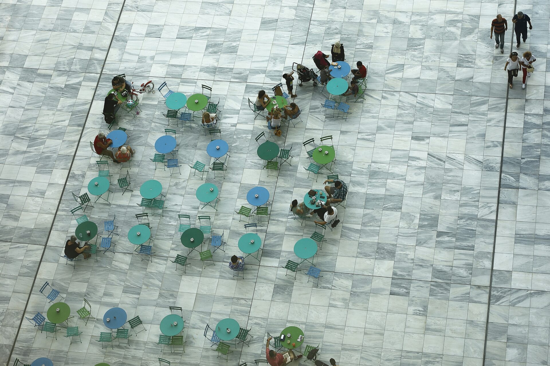 A group of people sitting around tables and chairs - Stavros Niarchos