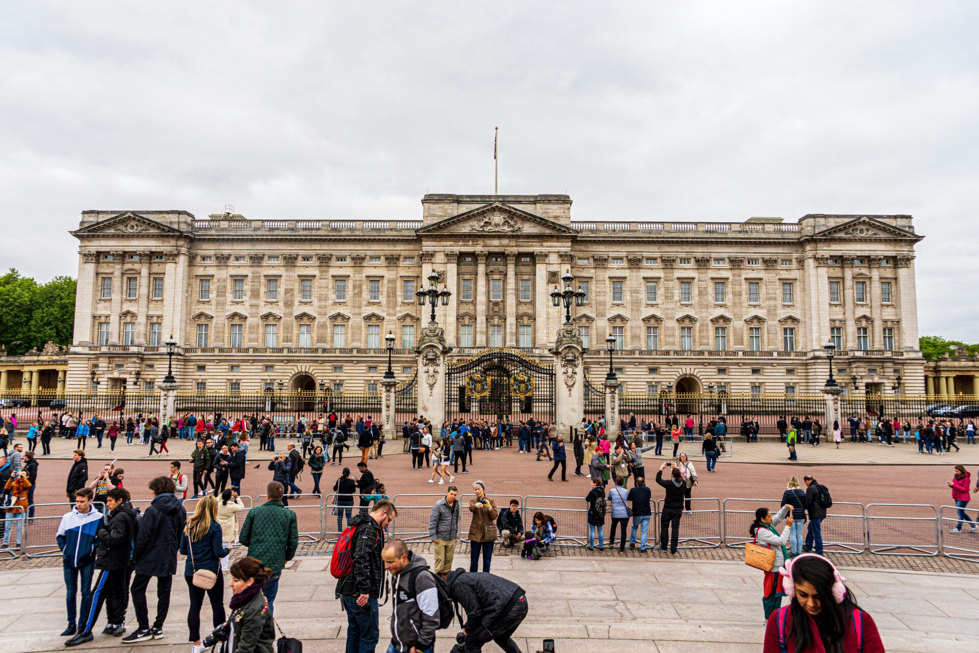 Tourists clustered around the entrance of Buckingham Palace.