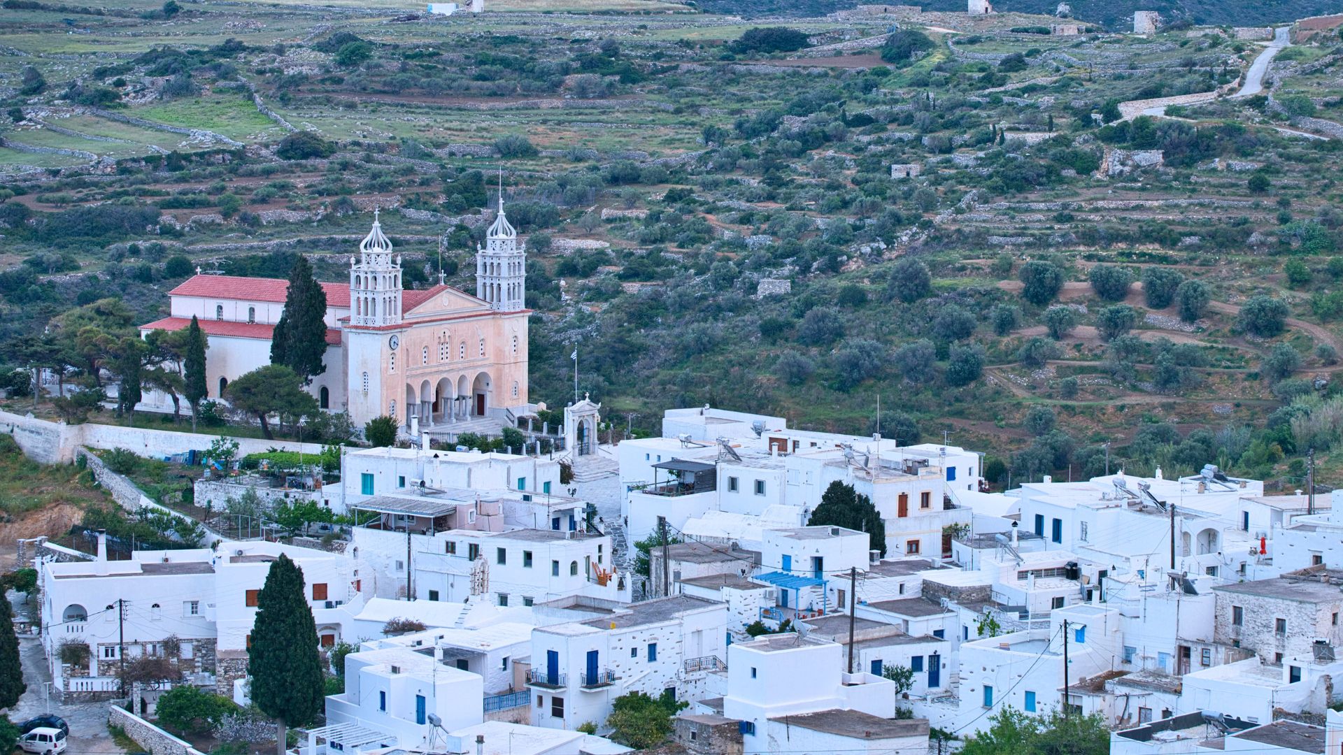 A high-angle view of Lefkes village in Paros, Greece, with its white buildings and a prominent church.
