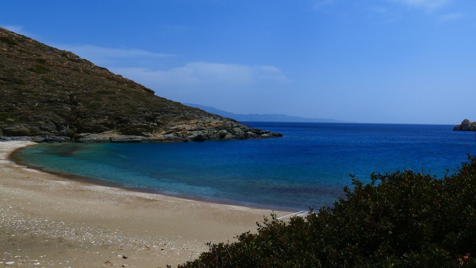 Agios Georgios Beach, Sikinos, Greece – tranquil golden sand and clear blue waters.