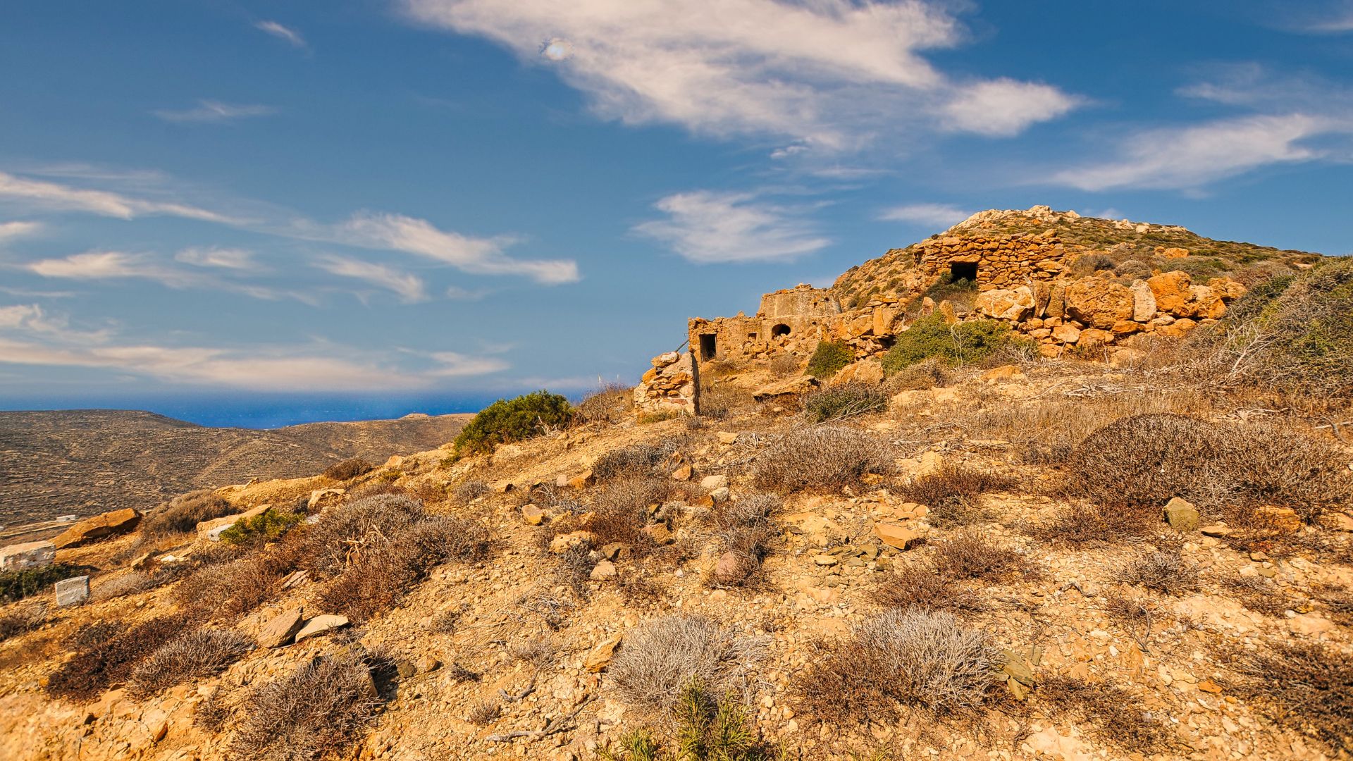 Anafi, Greece: Arid landscape with ancient ruins on a hillside overlooking the Aegean Sea.