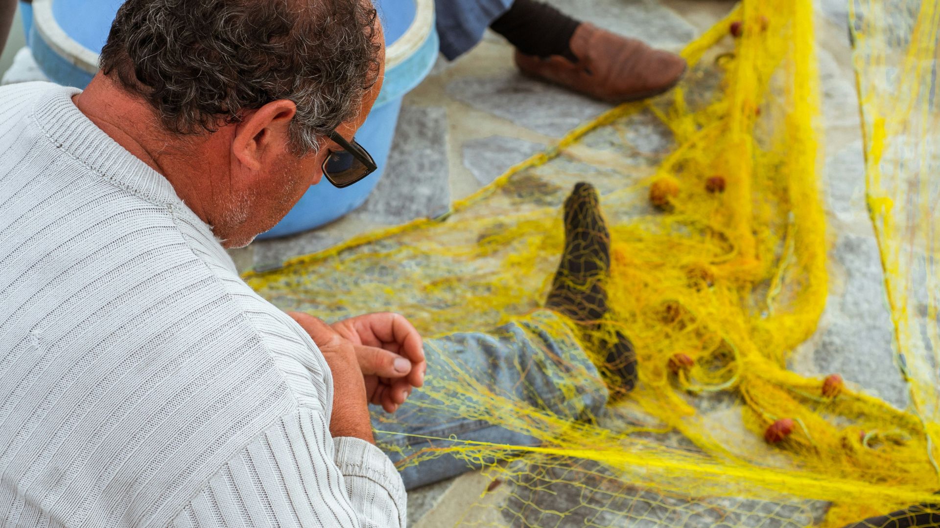 Fishermen repairing fishing net.