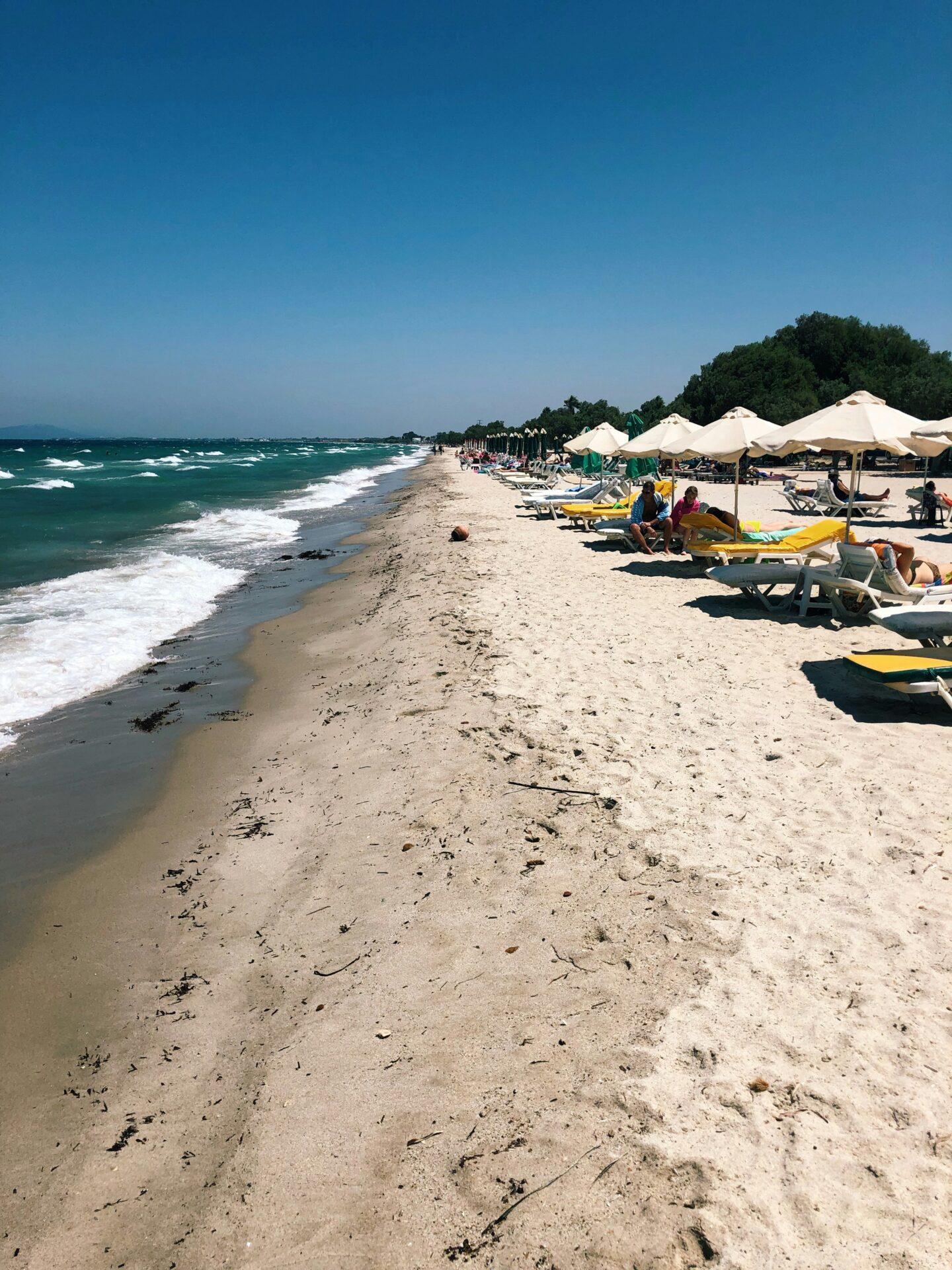 Beach line in Greece with sunbeds and umbrellas